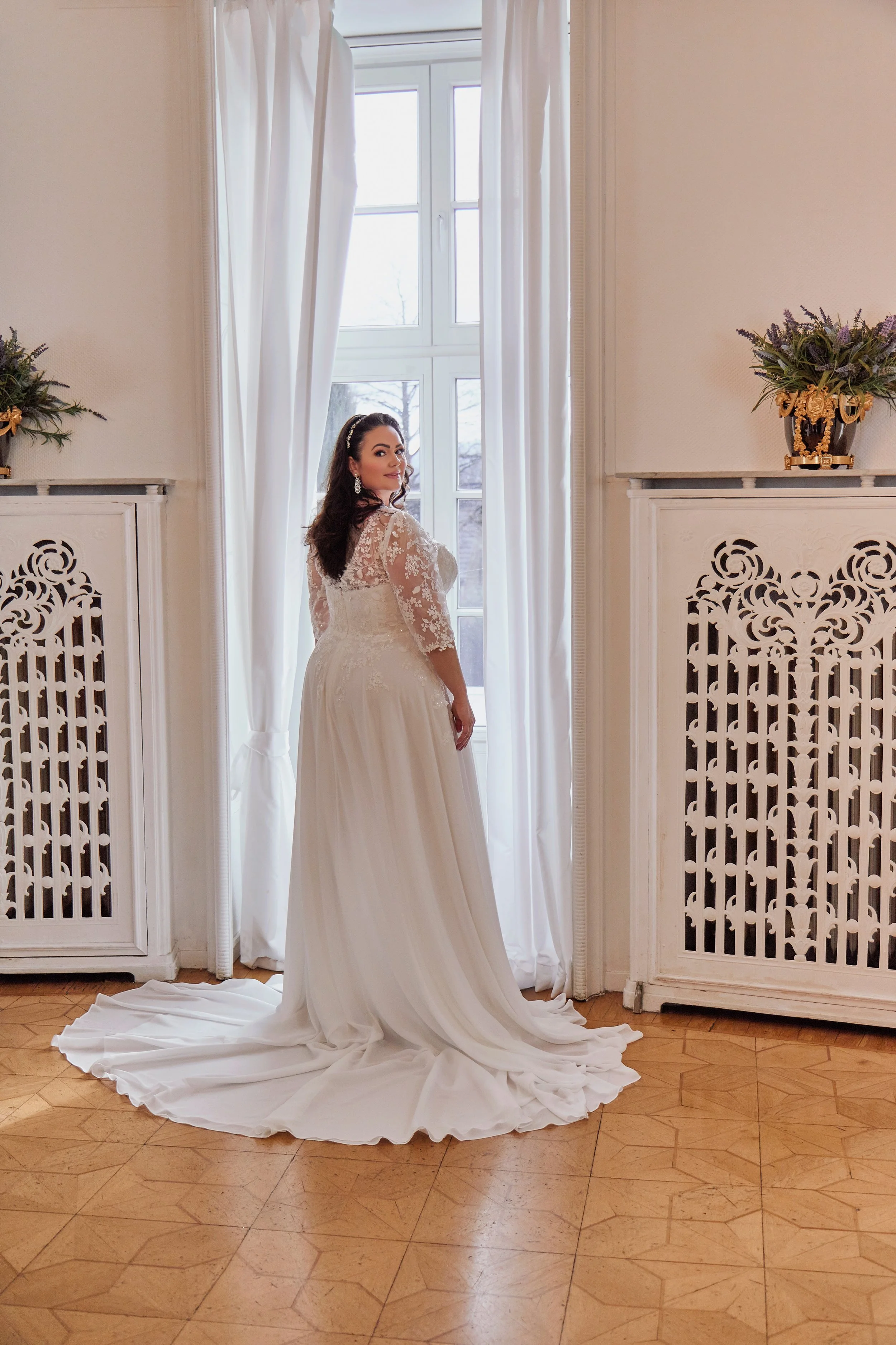 Back view of Lia Bella Model Trinity showing the illusion lace back, flowing A-line skirt and sweeping chiffon chapel train.