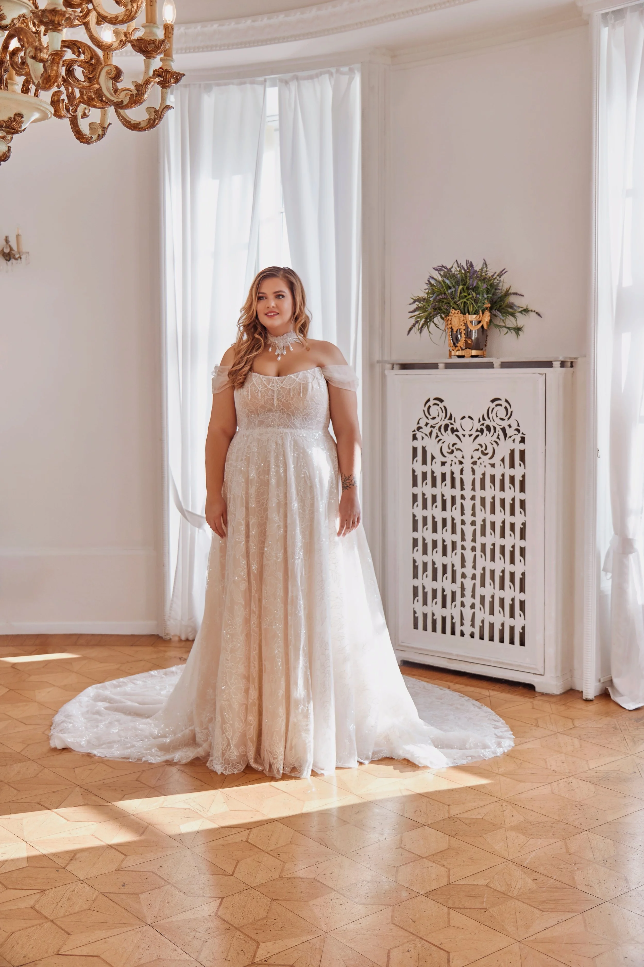 Full-length view of Lia Bella Model Temea featuring a flowing A-line skirt, floral embroidery and subtle shimmer.