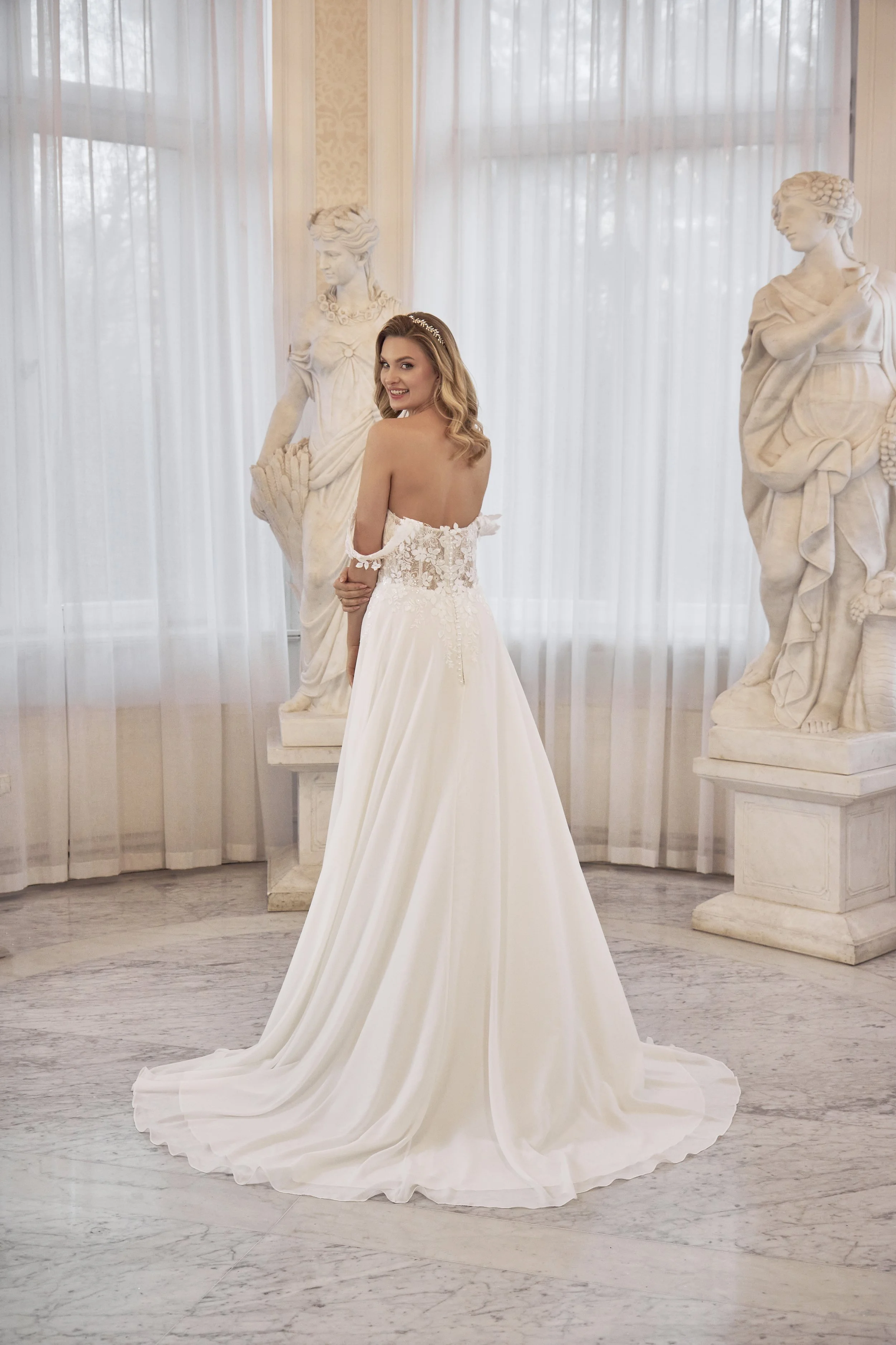 Back view of Lia Bella Model Theodora featuring a low illusion lace back, covered buttons and soft chapel train.