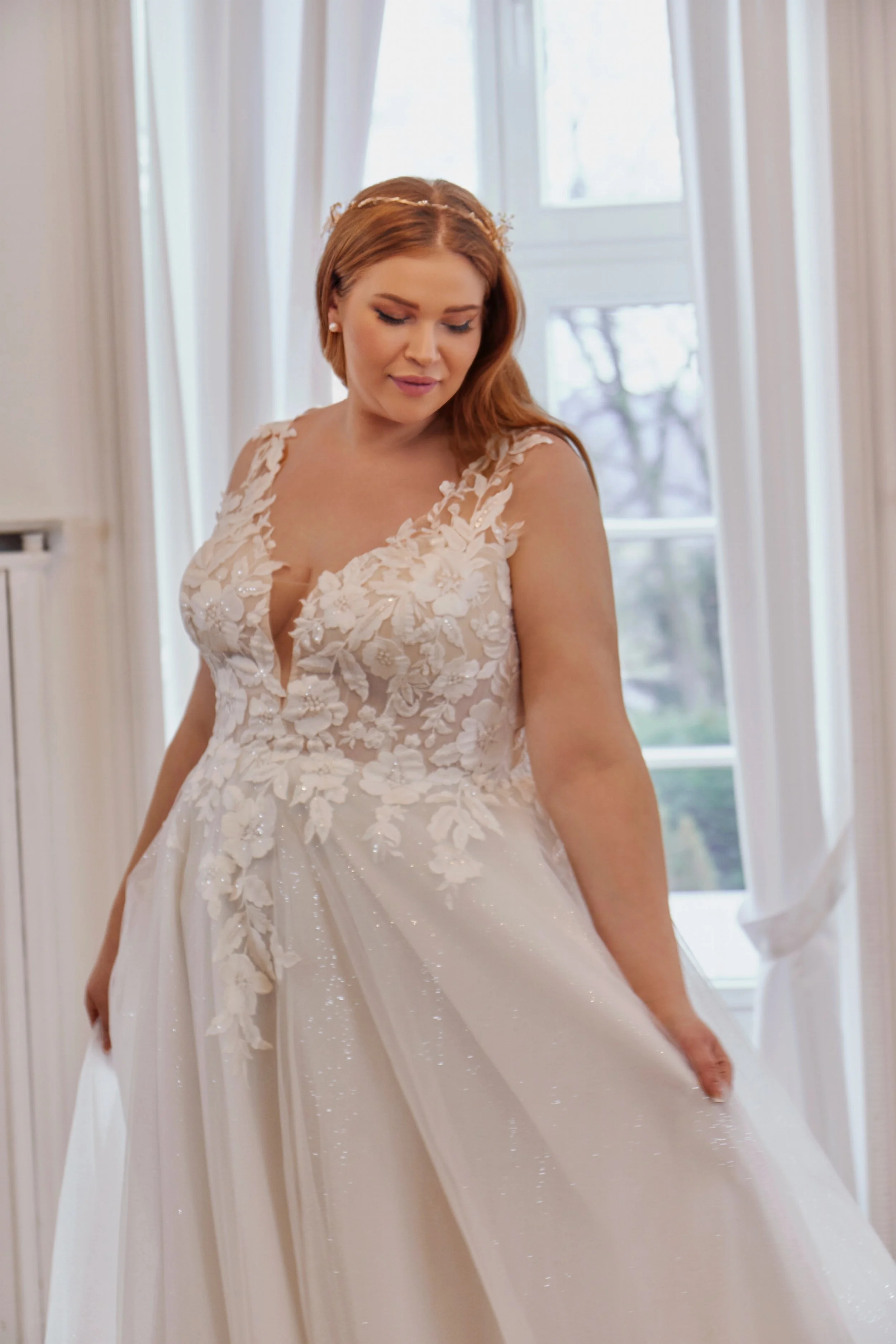 Side view of Lia Bella Model Tovi showing the structured floral lace bodice and softly shimmering glitter-tulle skirt.