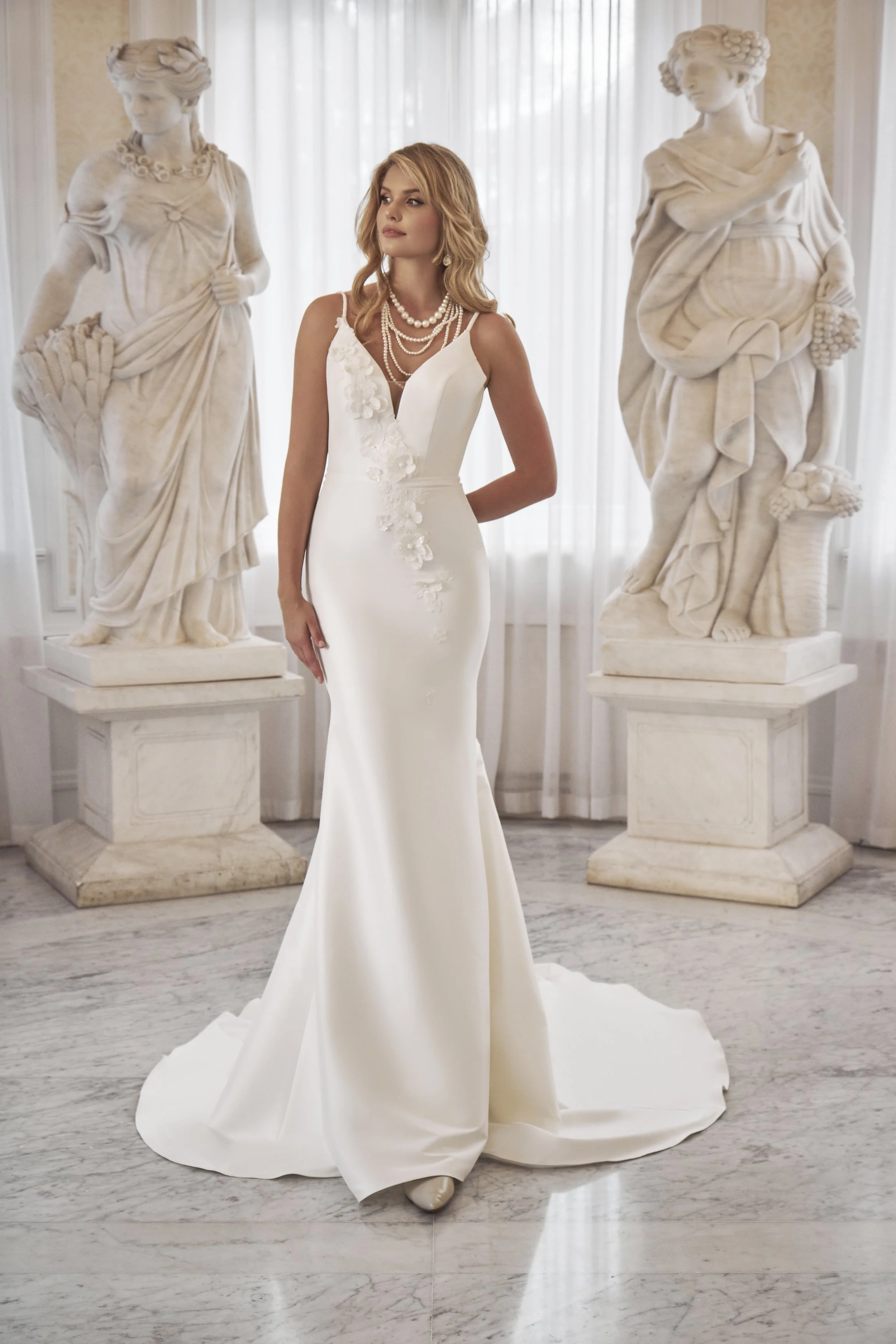 Full front view of Lia Bella Model Tafiana, a fit-and-flare wedding dress with a deep V-neckline and asymmetrical 3D floral appliqués.