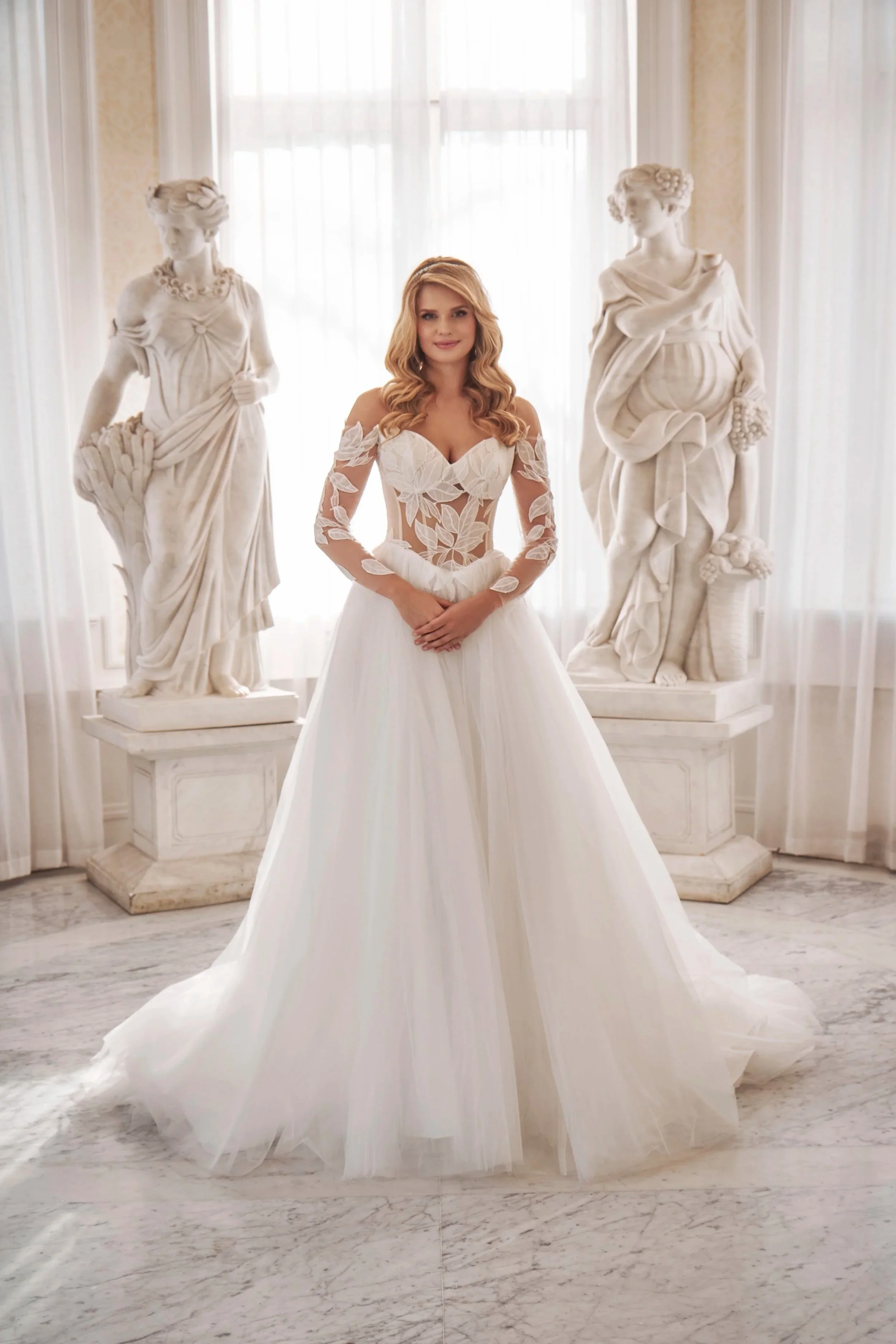 Front view of the ivory Tessa A-line wedding dress with floral lace and long lace sleeves from Lia Bella RÊVE 2027.