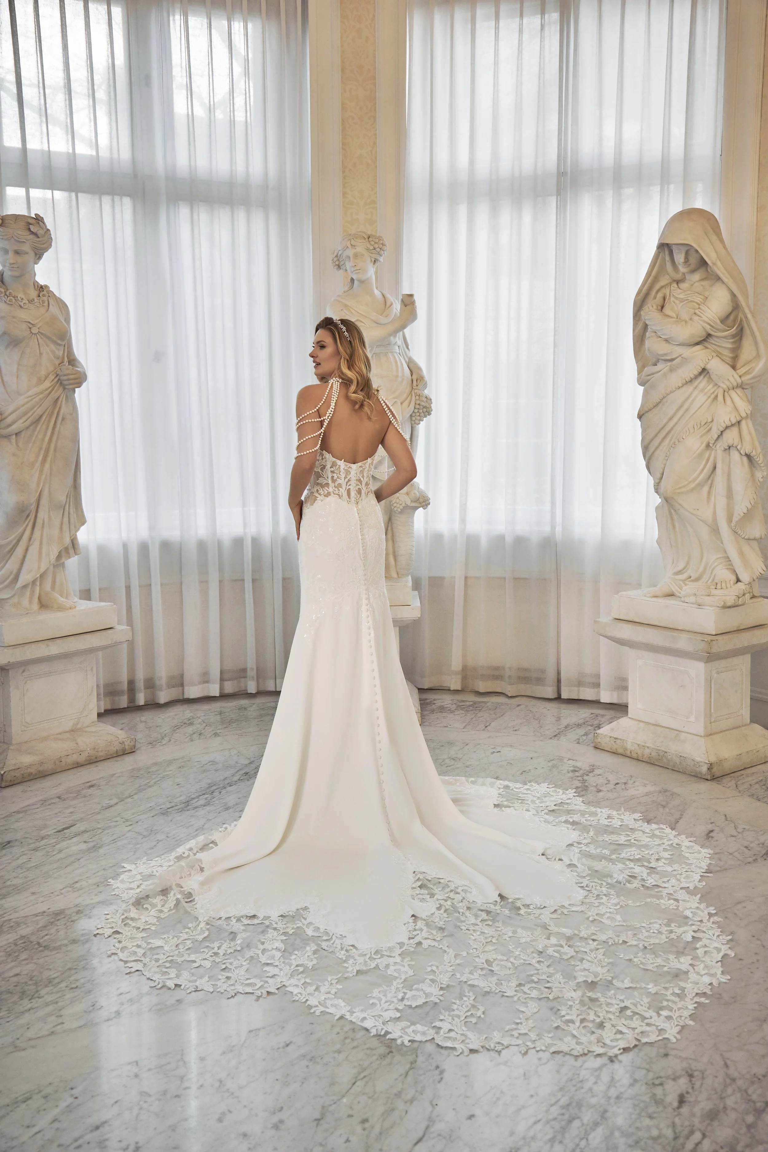 Full back view of Lia Bella Model Talisa showing the low illusion back, covered buttons and lace-bordered cathedral train.
