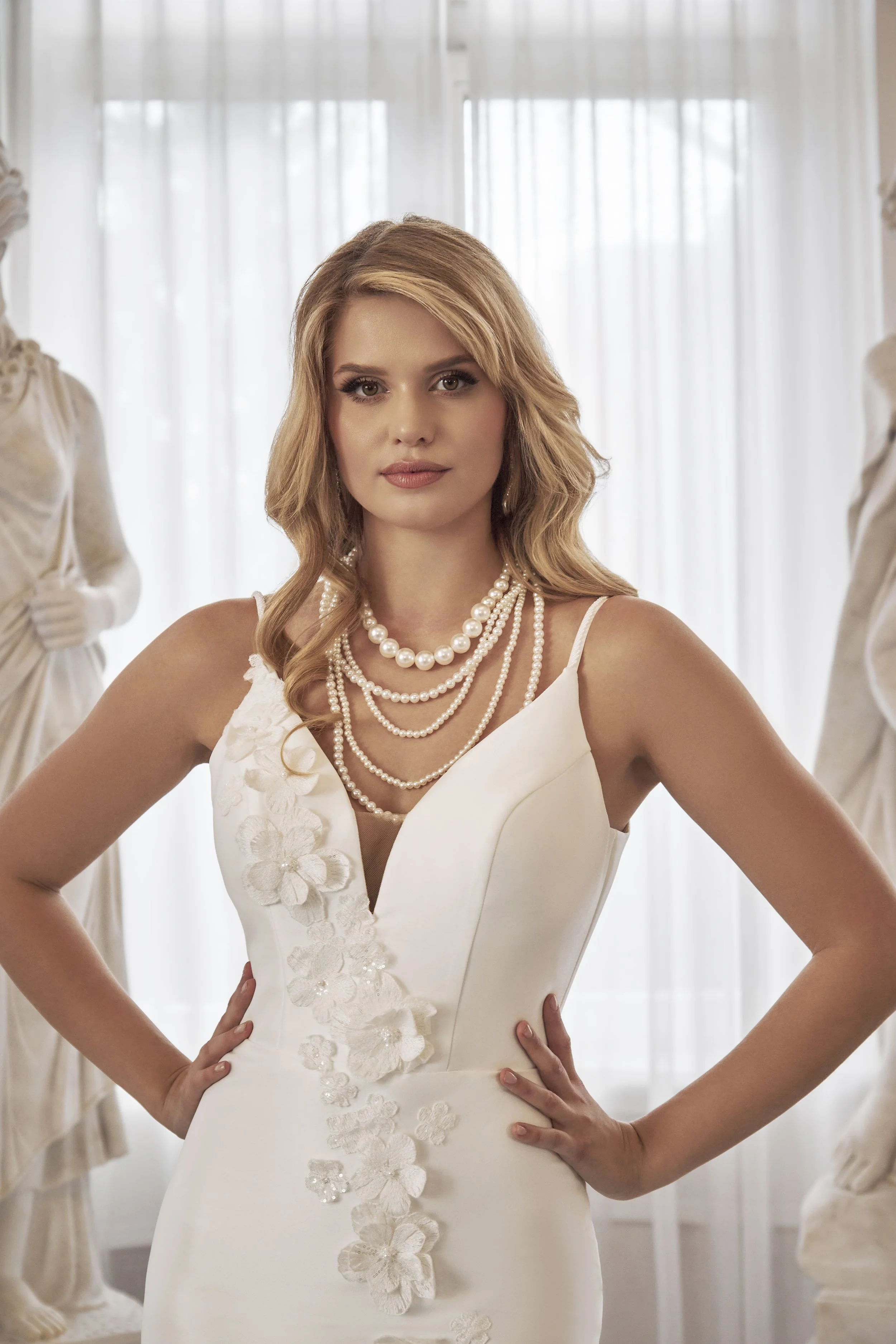 Close-up of Lia Bella Model Tafiana featuring a plunging V-neckline, slender straps and embellished 3D floral appliqués.