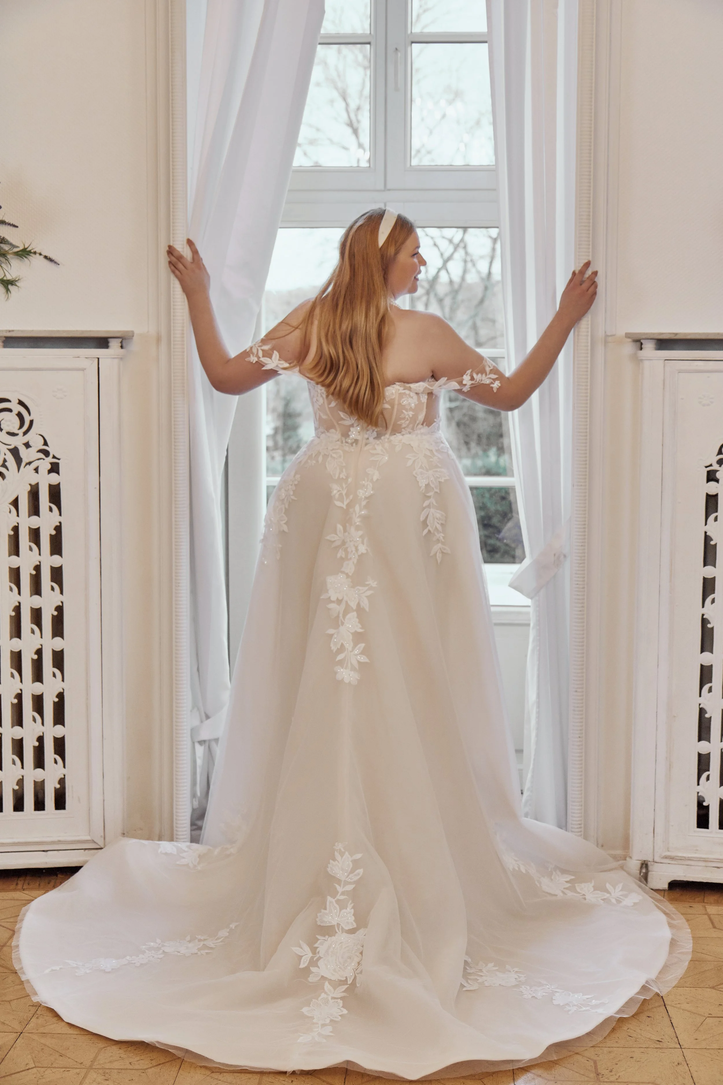 Full back view of Lia Bella Model Tazia showing the illusion lace bodice, covered buttons and floral chapel train.