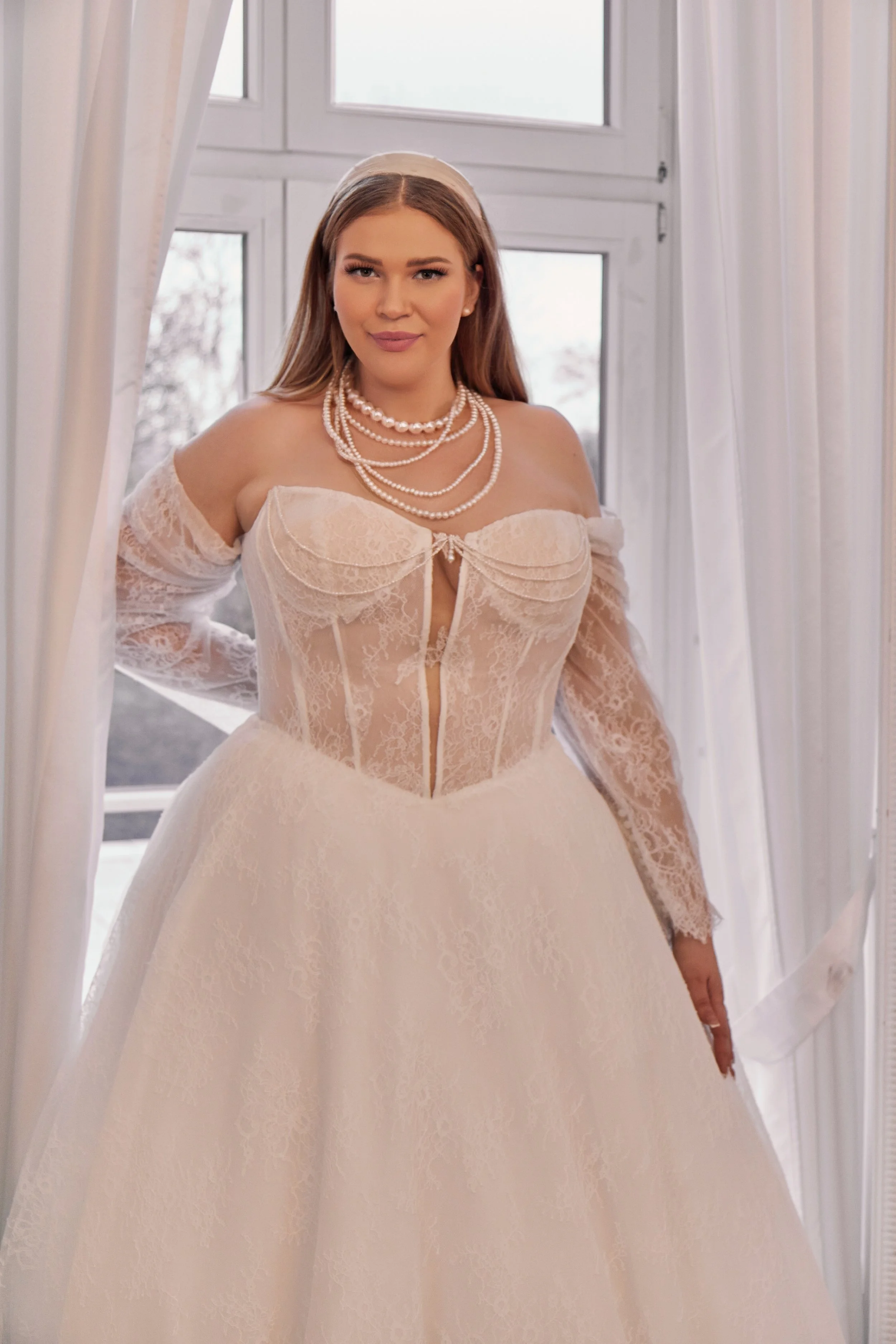 Close-up of Lia Bella Model Tia highlighting the layered lace cups, narrow plunging inset and structured illusion corset.