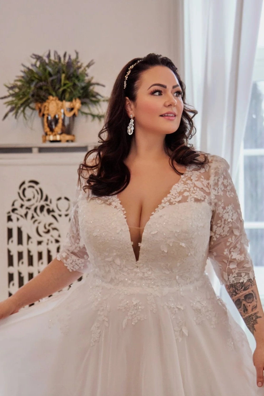 Close-up of Lia Bella Model Trinity highlighting the deep V-neckline, beaded floral lace bodice and transparent lace sleeves.