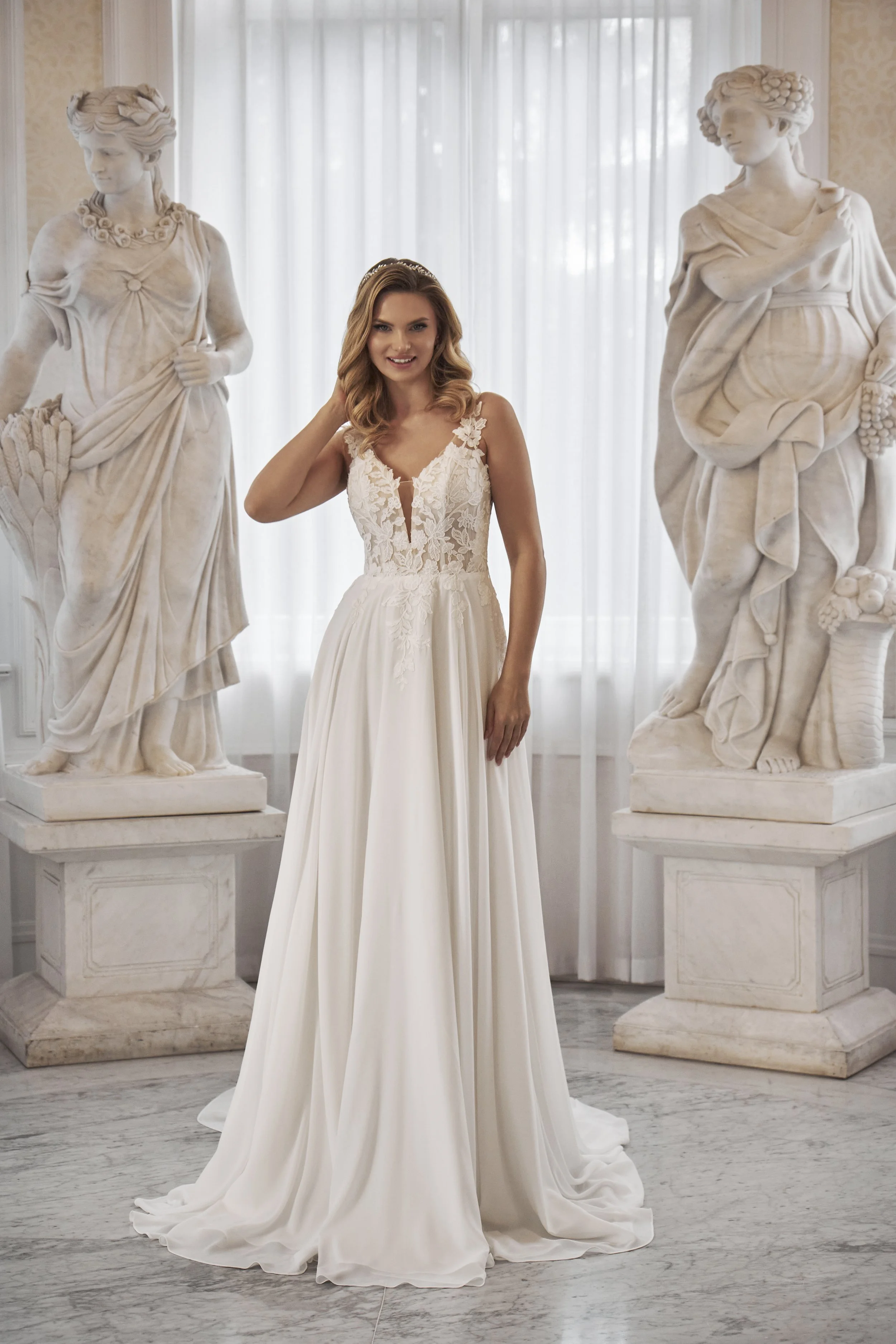 Full front view of Lia Bella Model Tekla, a flowing A-line wedding dress with a plunging V-neck and floral lace bodice.