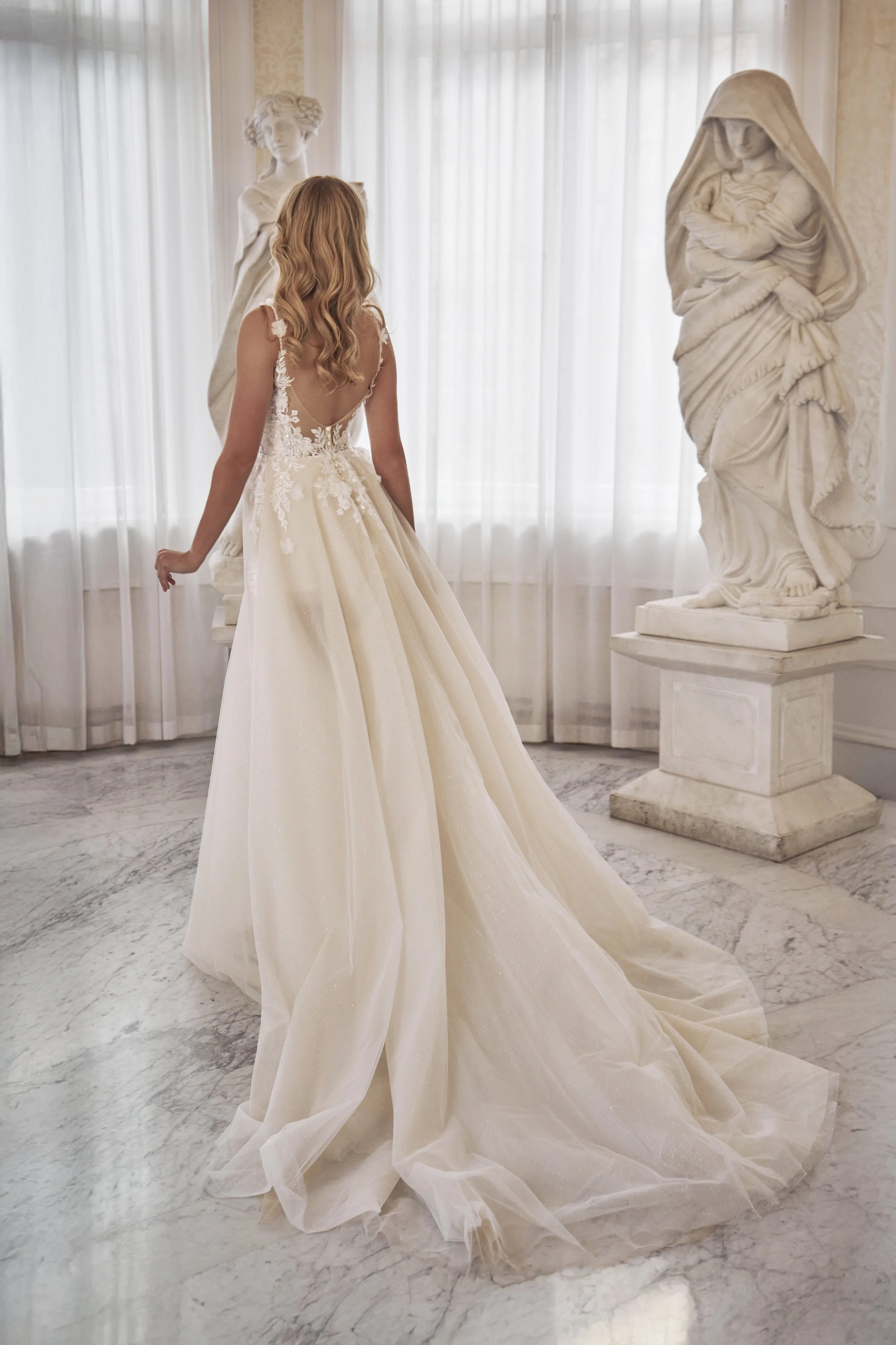Full back view of Lia Bella Model Tizia showing the low scoop back, shimmering tulle skirt and flowing chapel train.