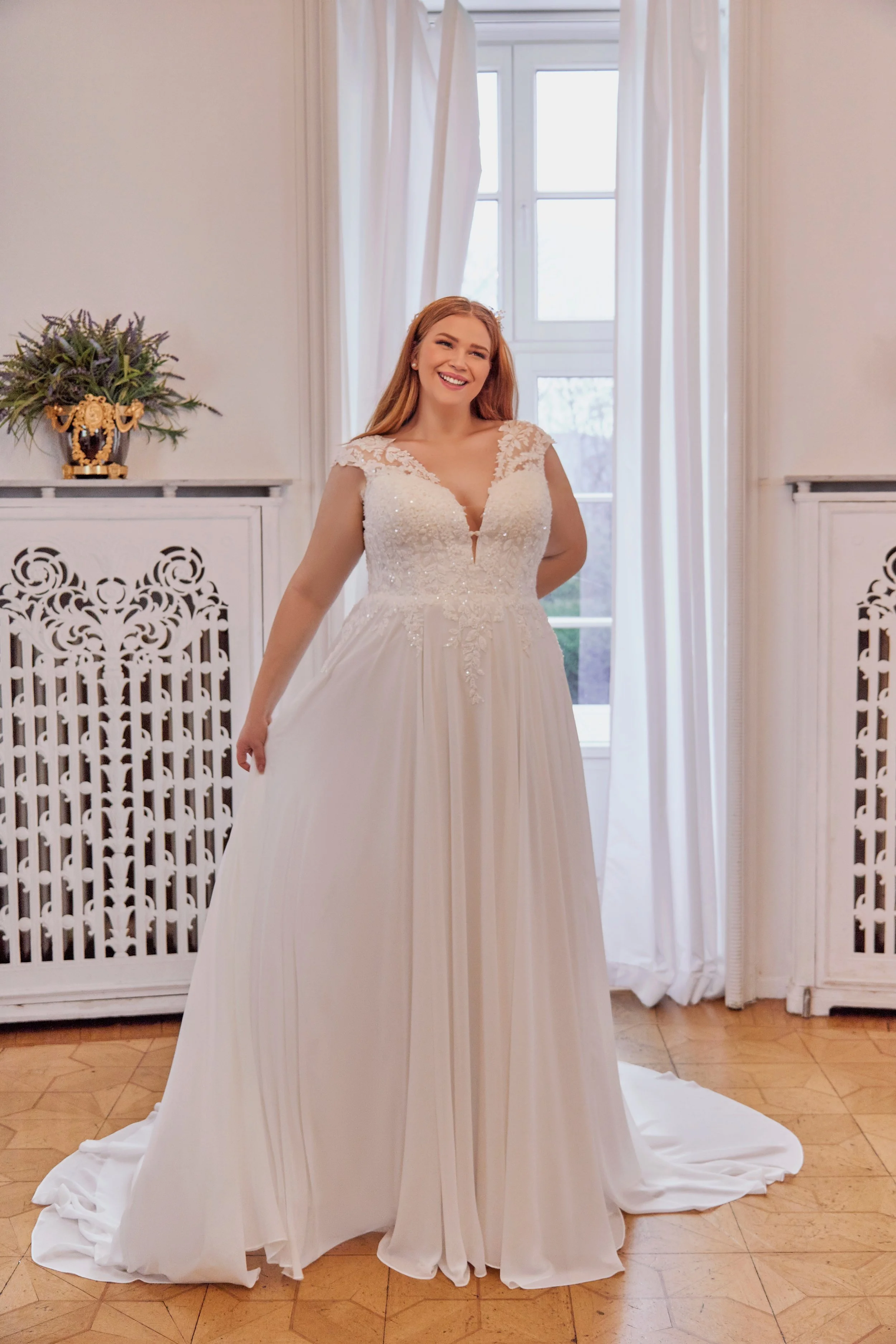 Full front view of Lia Bella Model Tracy, a curvy A-line wedding dress with a beaded floral lace bodice and flowing chiffon skirt.