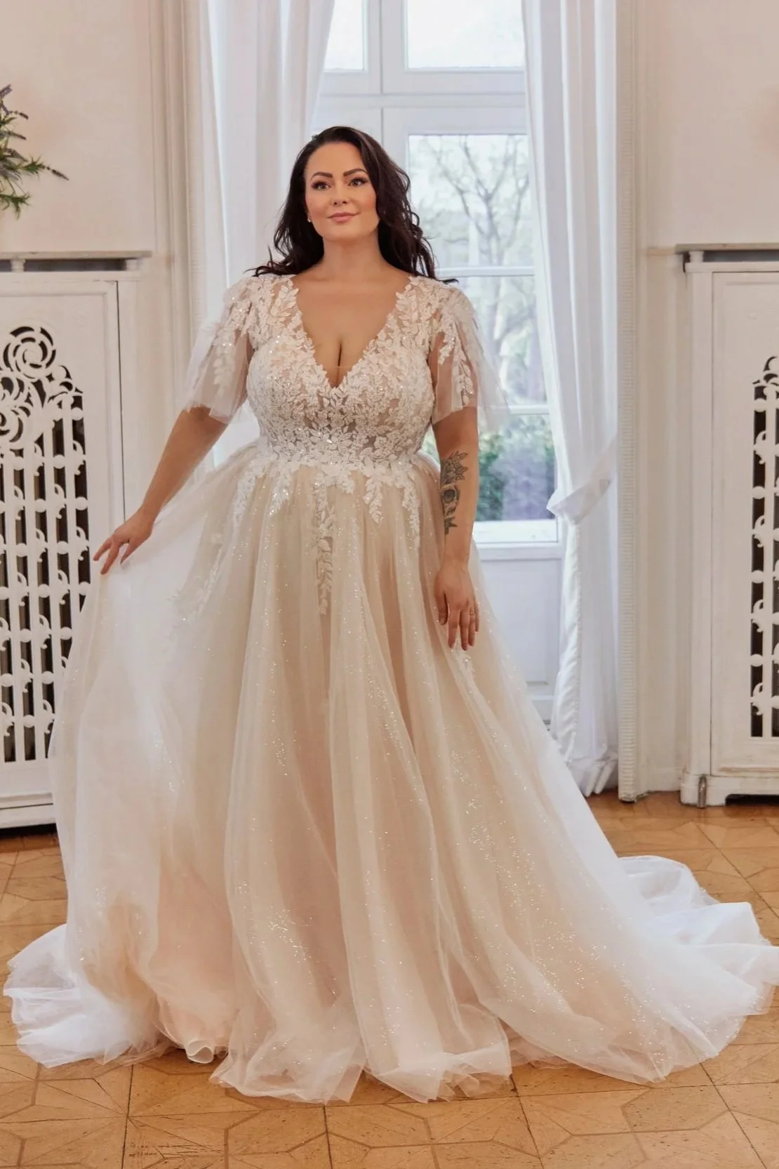 Wide front view of Lia Bella Model Tamika showing its softly flowing A-line silhouette, lace bodice and glitter tulle skirt.