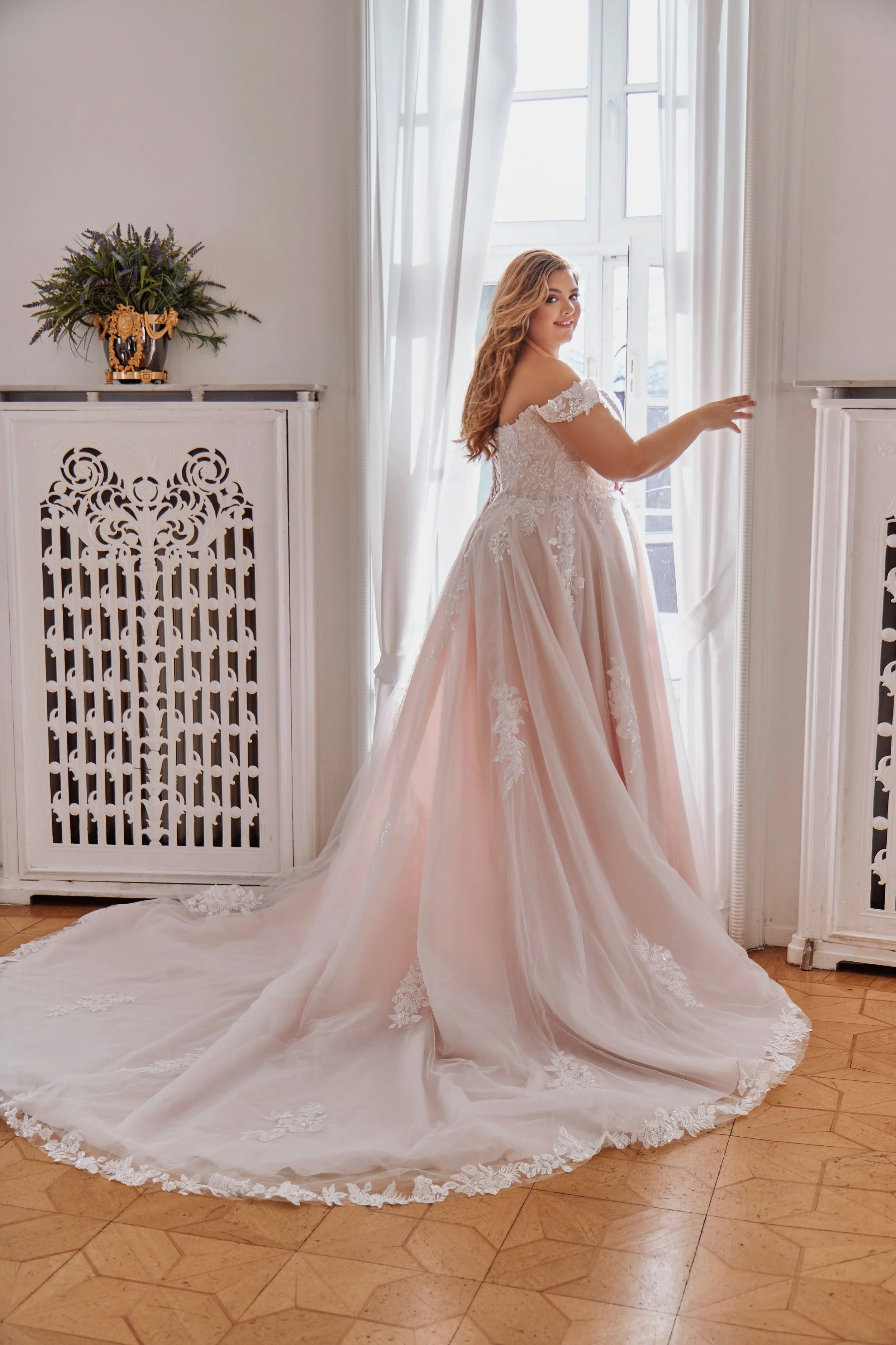 Full back view of Lia Bella Model Tasmine showing its flowing A-line skirt and wide chapel train finished with floral lace.