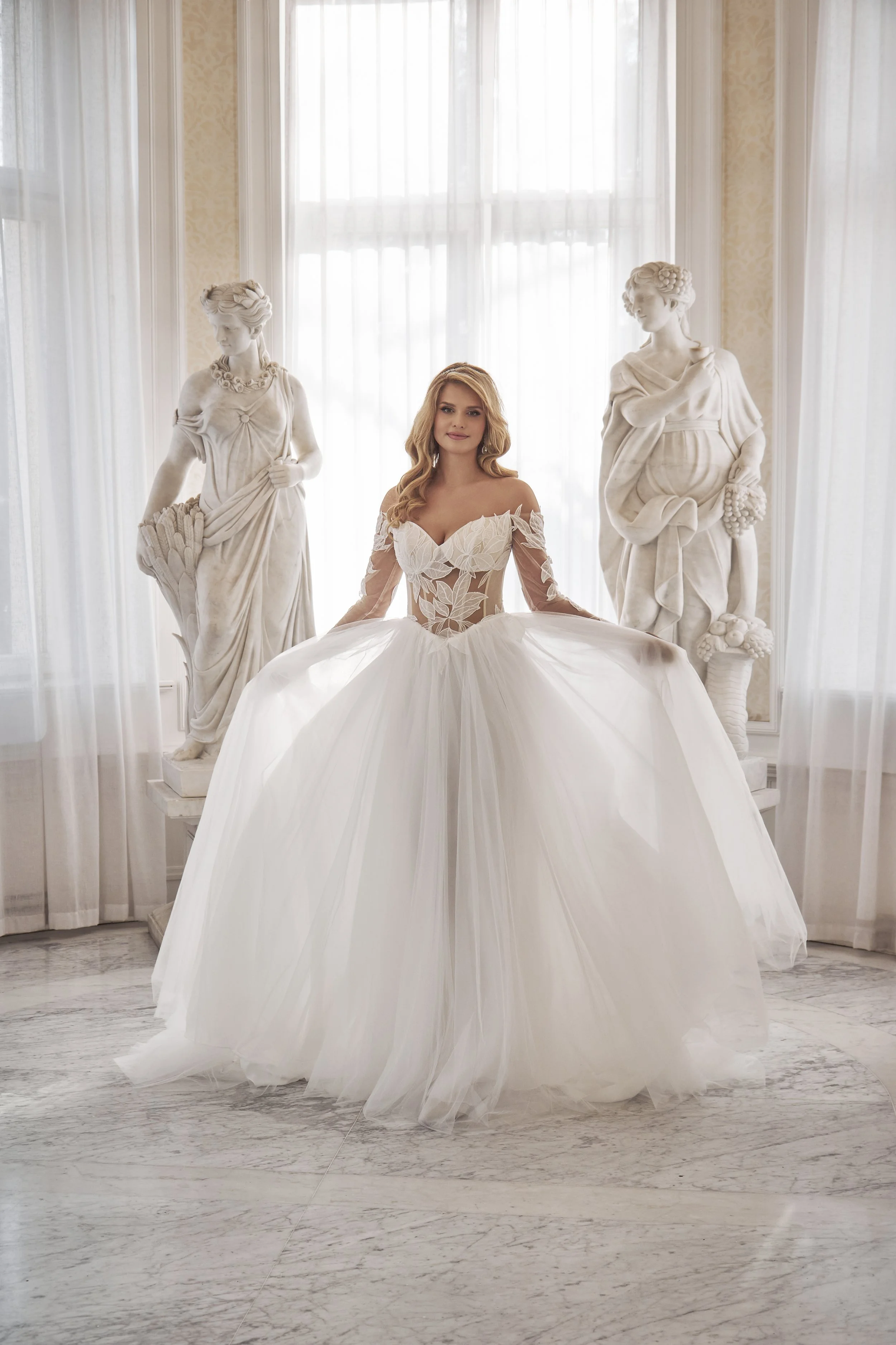 Bride wearing the Lia Bella Tessa A-line wedding dress with a sheer leaf-lace bodice and lace sleeves.
