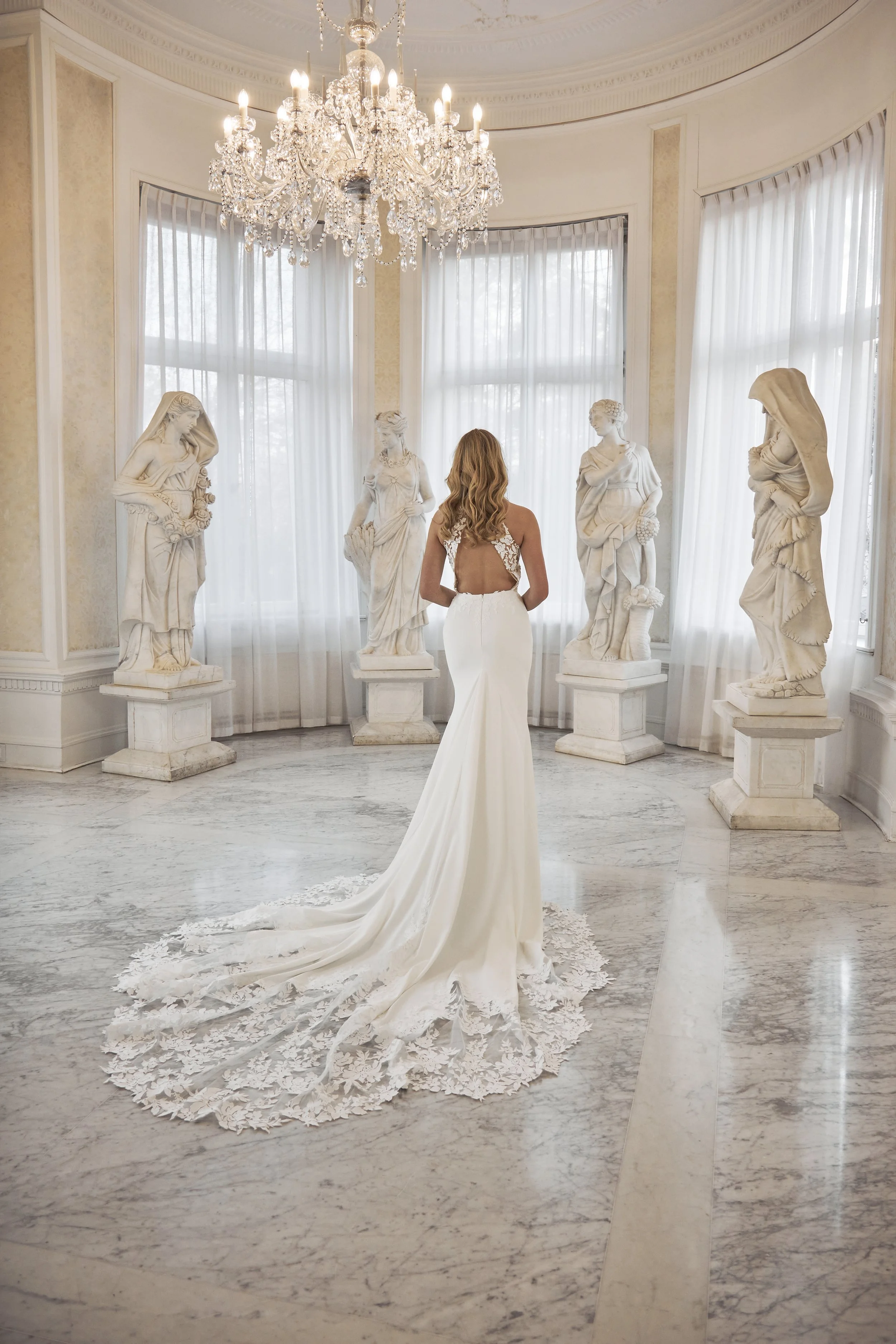 Full back view of Lia Bella Model Tilda showing the fitted crepe silhouette, low open back and lace-edged cathedral train.