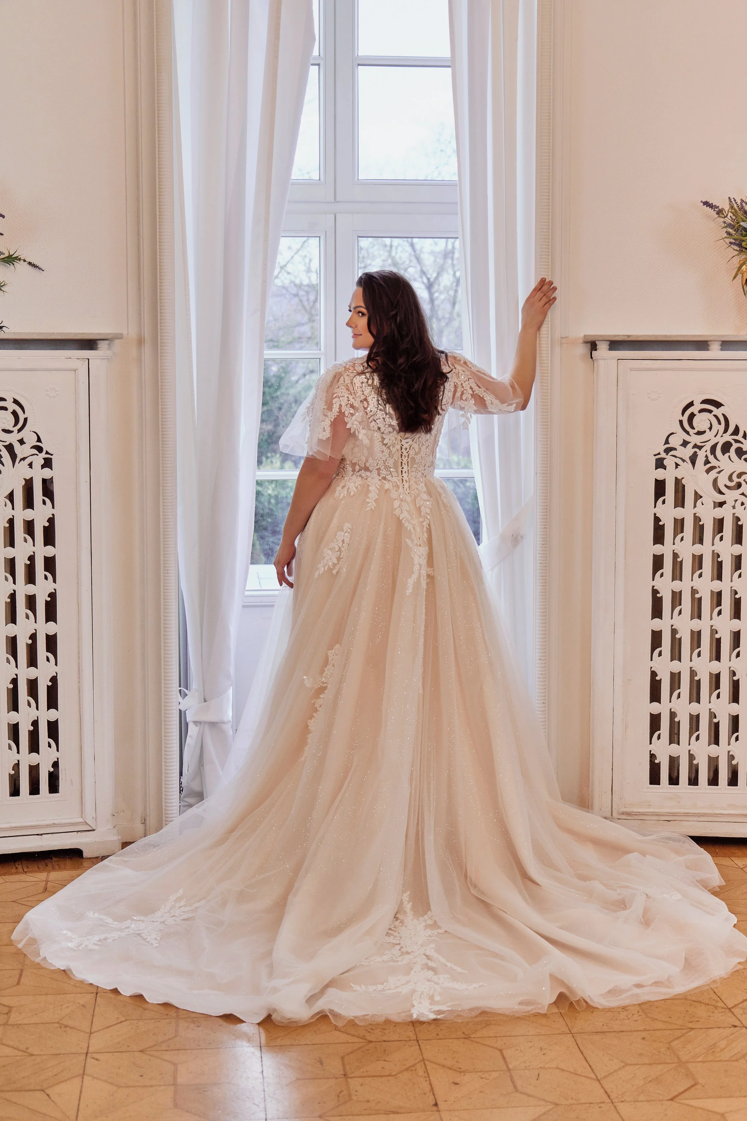 Full back view of Lia Bella Model Tamika highlighting the lace-up corset, floral appliqués and flowing chapel train.