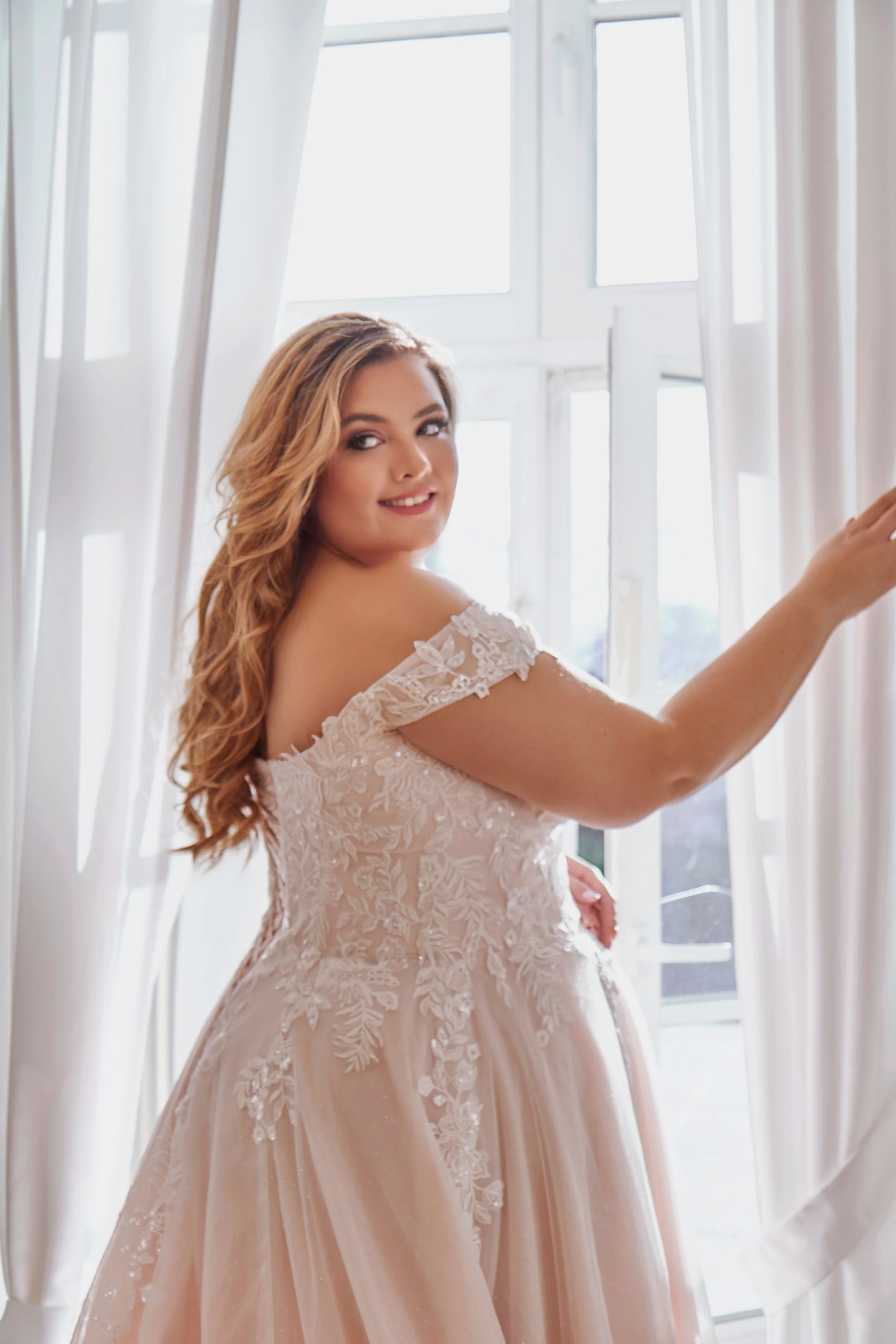 Three-quarter back detail of Lia Bella Model Tasmine highlighting the floral lace bodice and off-the-shoulder lace straps.
