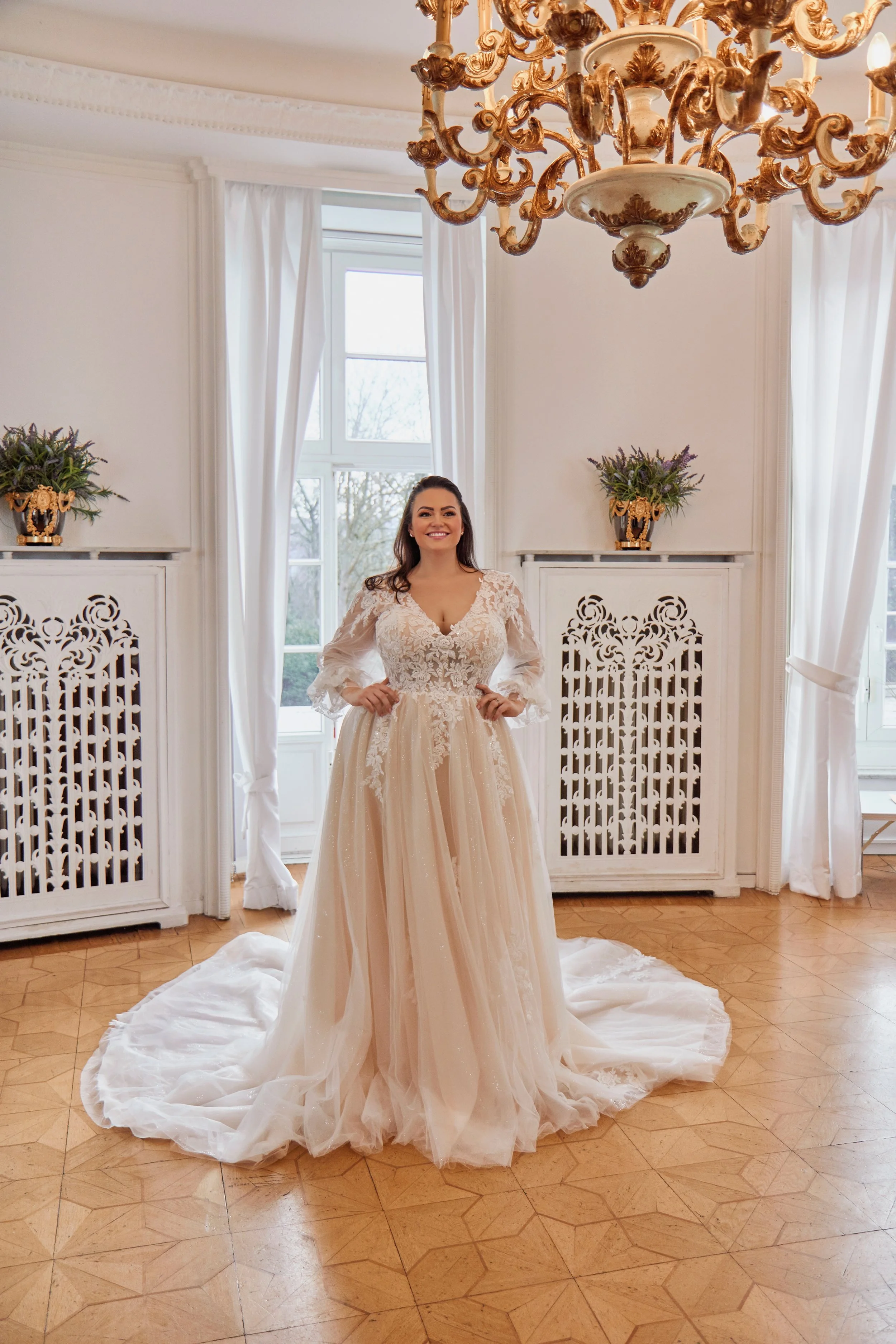 Full-length front view of Lia Bella Model Tiede displaying the softly voluminous A-line skirt and lace-trimmed chapel train.