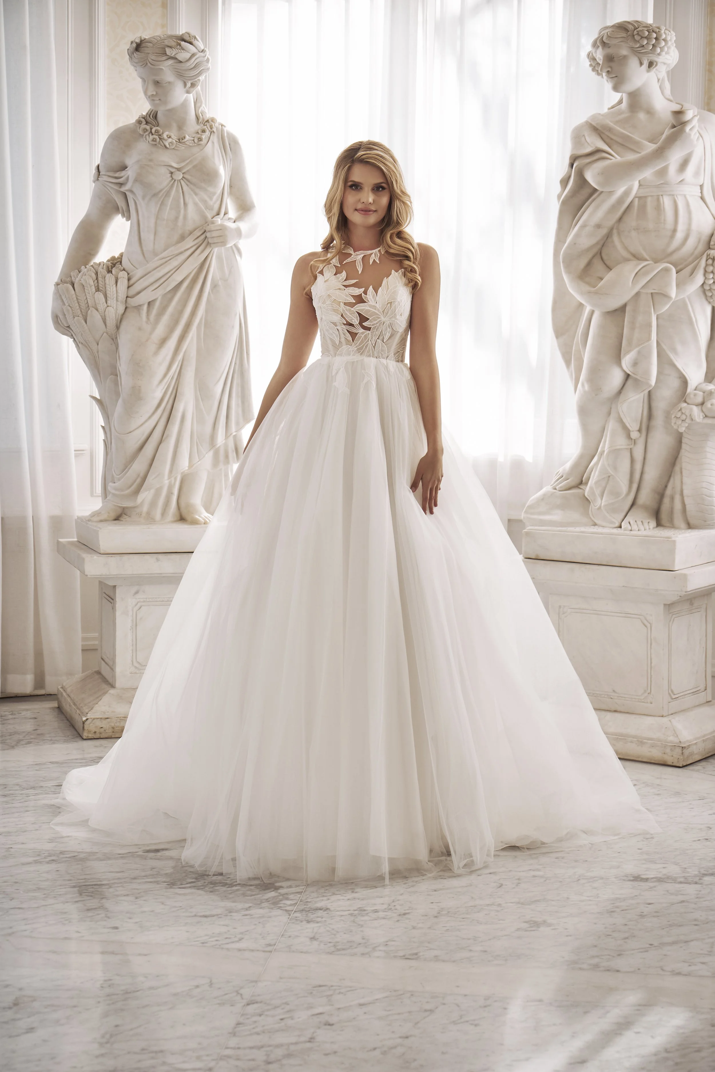 Full front view of Lia Bella Model Tat, a ball gown wedding dress with a botanical lace bodice and layered tulle skirt.
