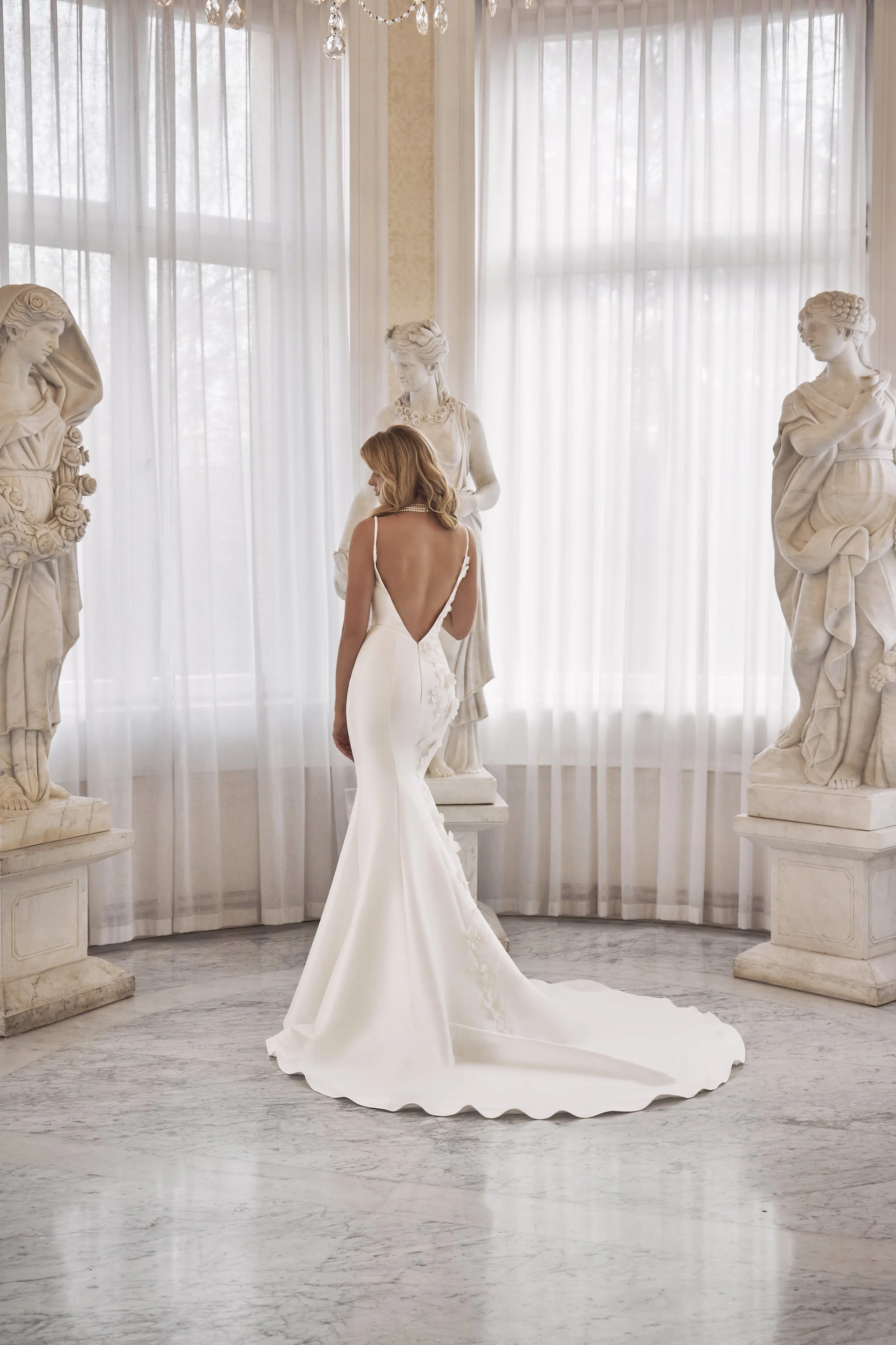 Back view of Lia Bella Model Tafiana with a deep V-back, fitted silhouette and fluid chapel train.
