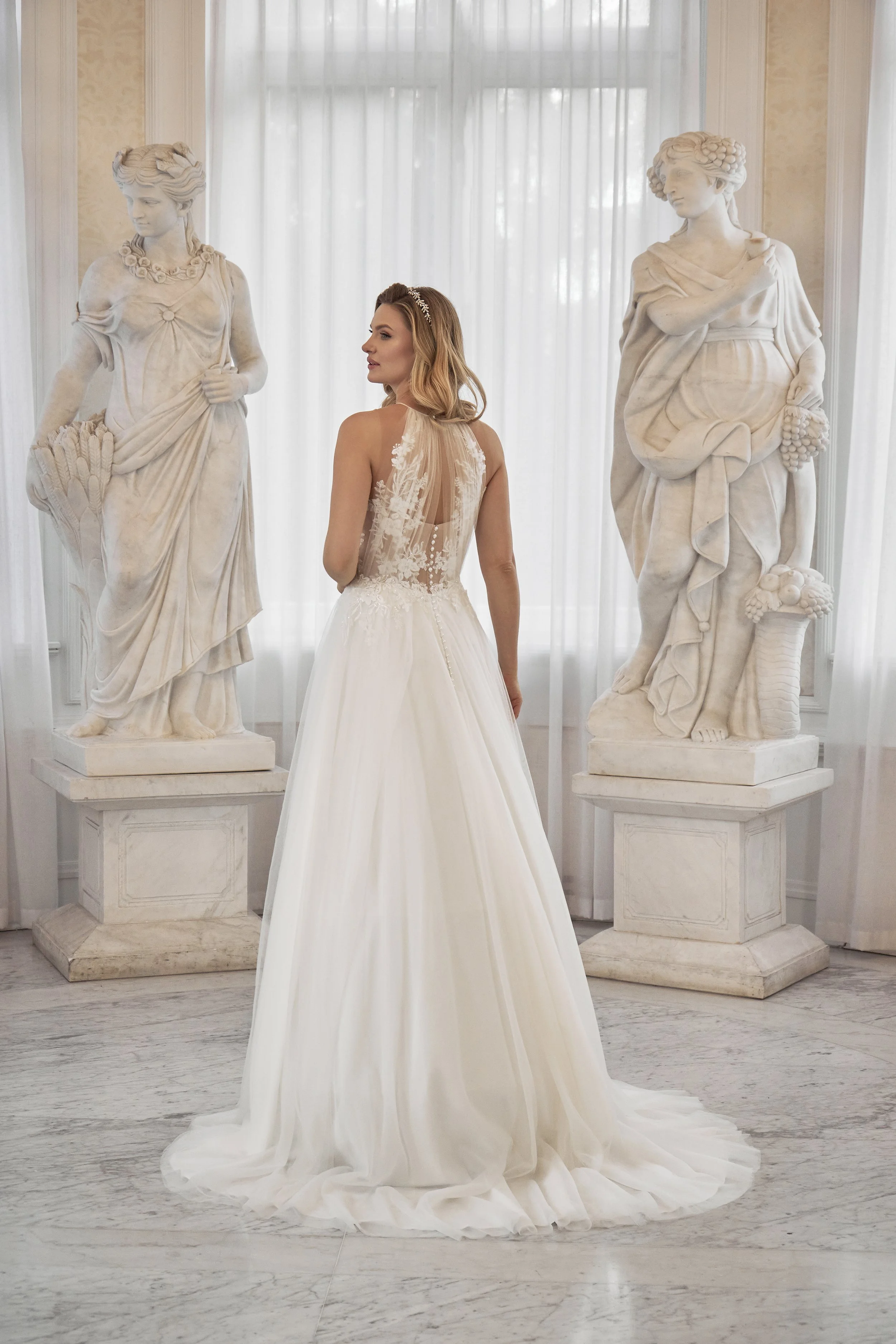 Full back view of Lia Bella Model Toutou showing the high illusion lace back, covered buttons and softly flowing chapel train.