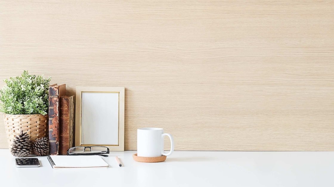 Minimalist desk with books, a mug and notepad