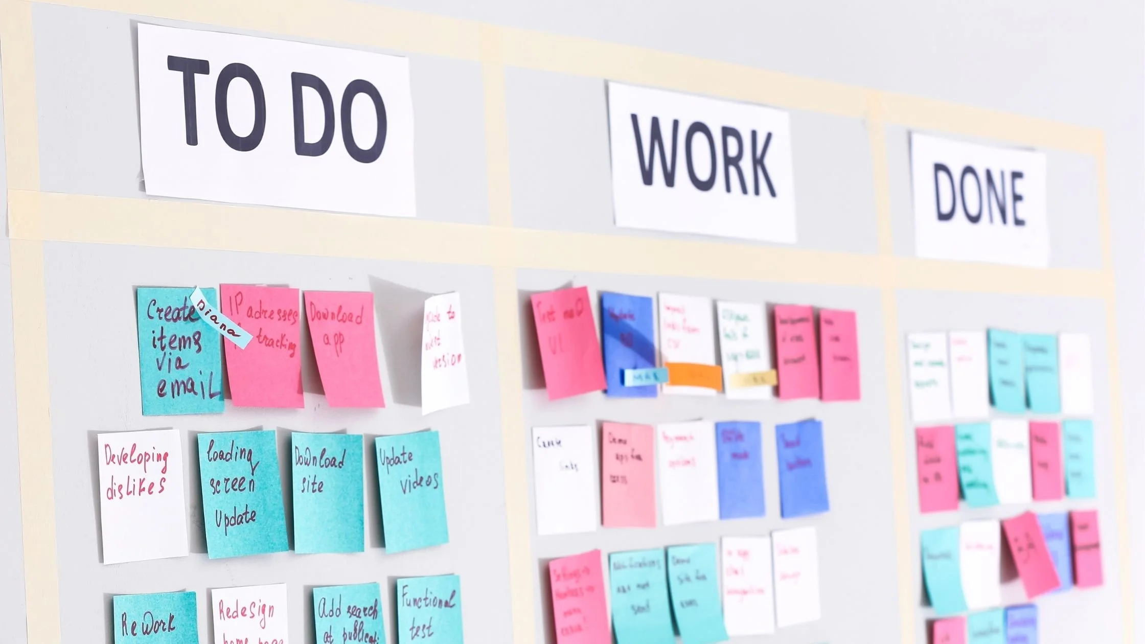 Minimalist Kanban board with colorful post-it notes showing a simple task workflow.