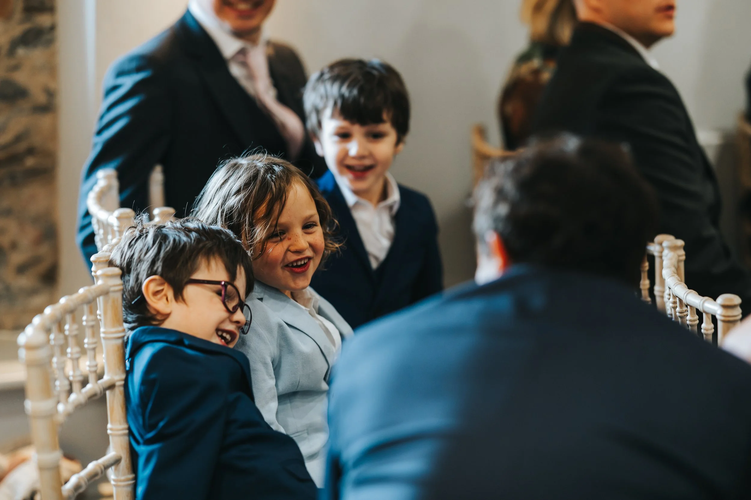 Children and adults enjoying a conversation at a social gathering indoors.