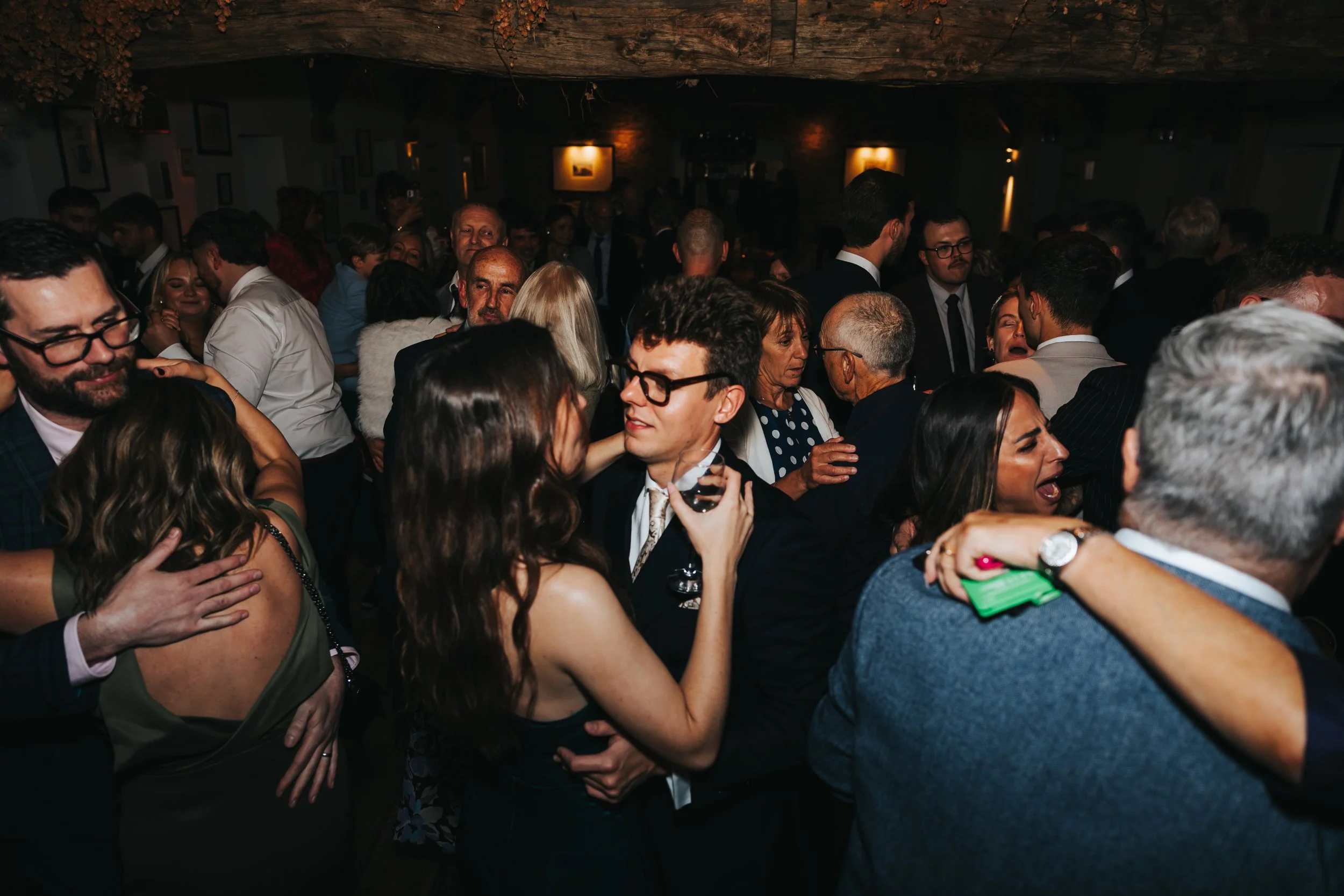 People dancing and socializing at a crowded indoor party or celebration.
