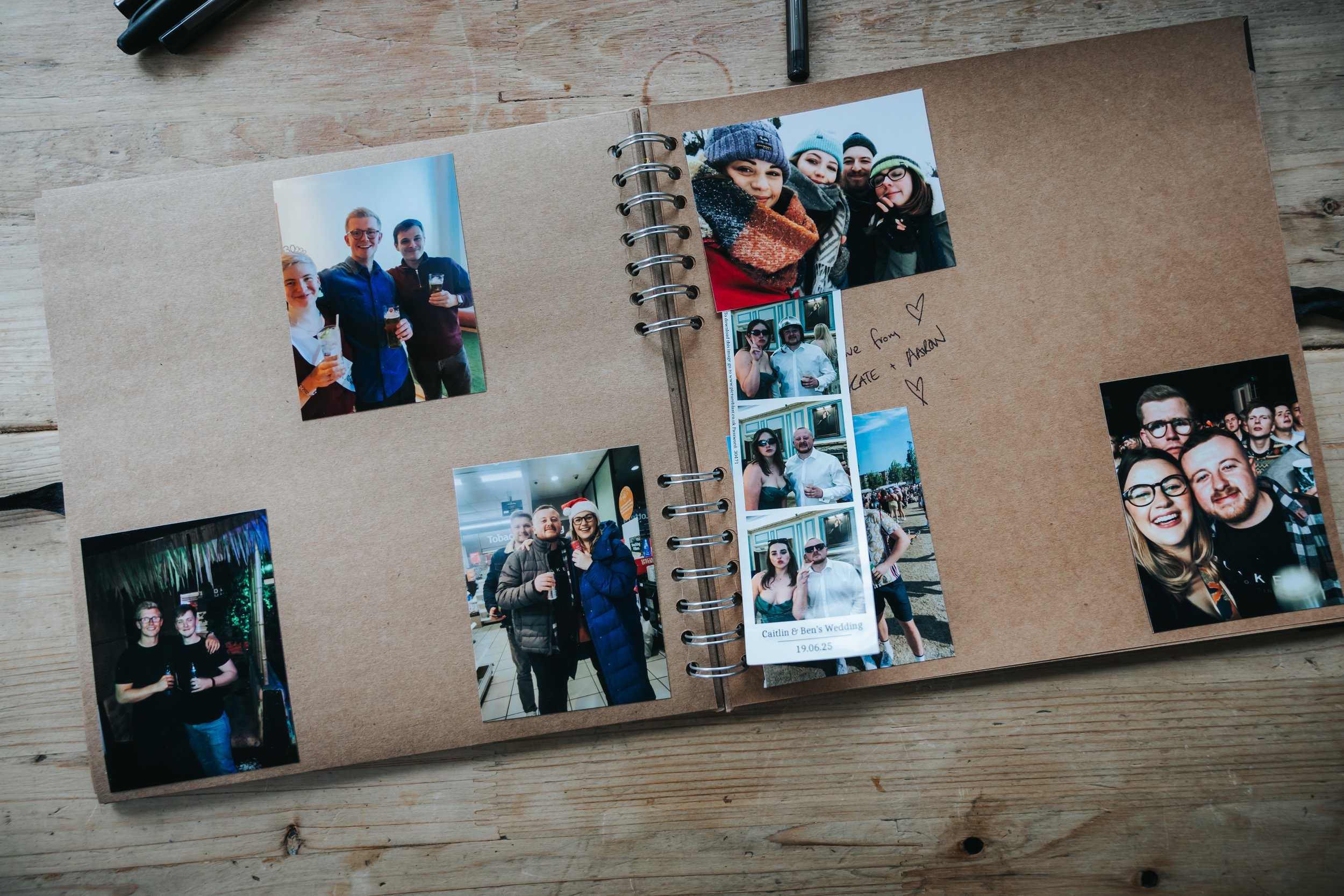 An open photo album with multiple pictures of people at social gatherings, some wearing winter clothing and holding drinks, on a wooden surface.