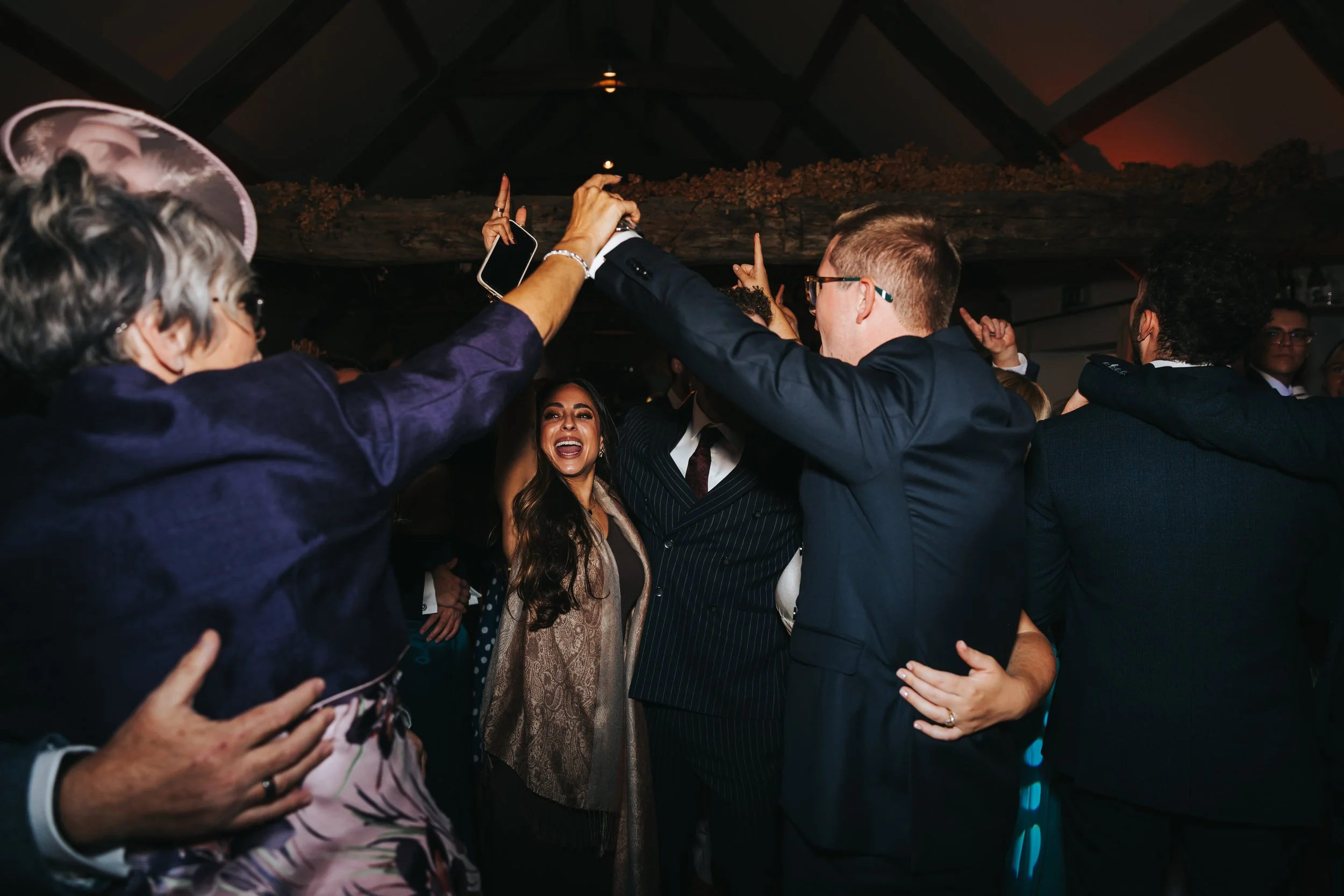 People dancing closely together at a celebration or party, smiling and enjoying the moment.