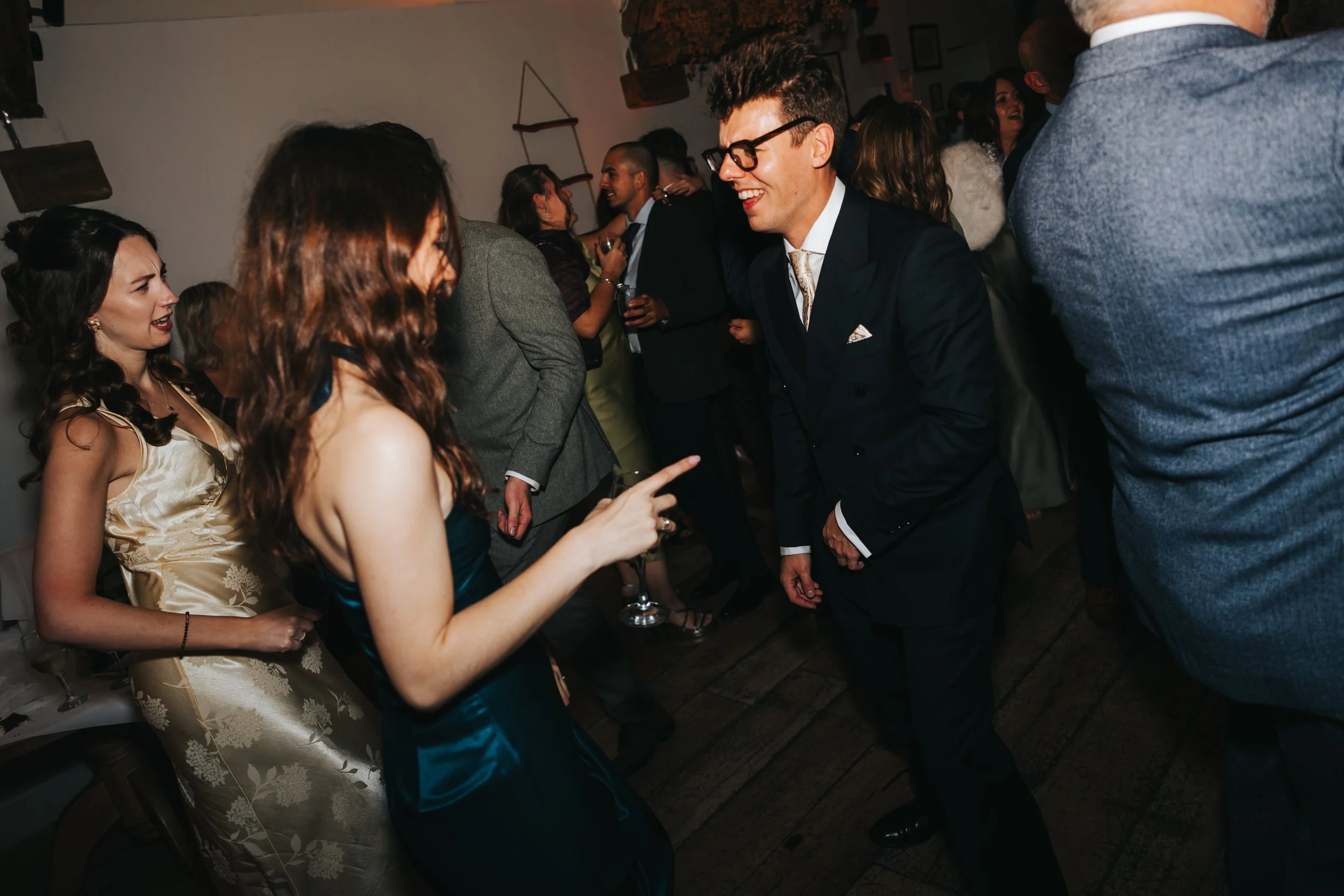 People dancing and socializing at a party, with a man and woman engaging and smiling.