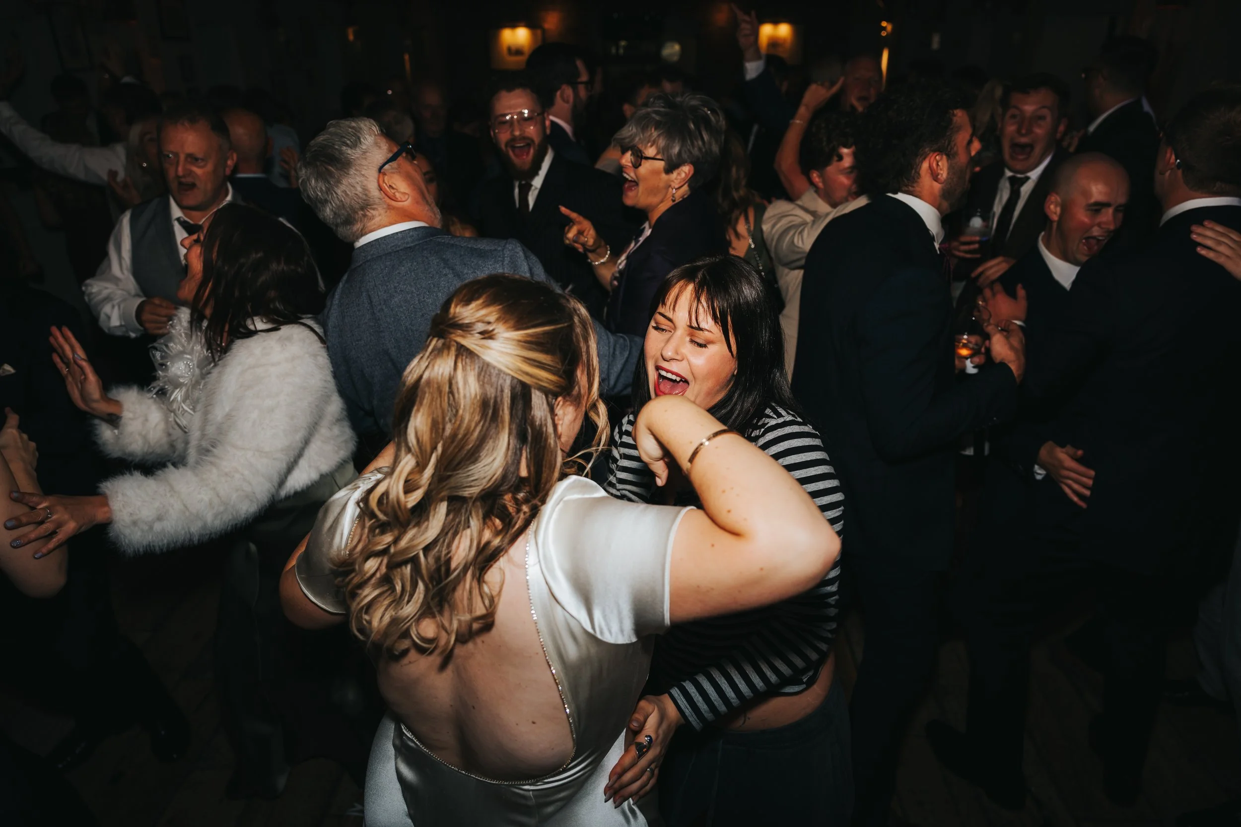 People dancing and celebrating at a lively party or wedding reception.