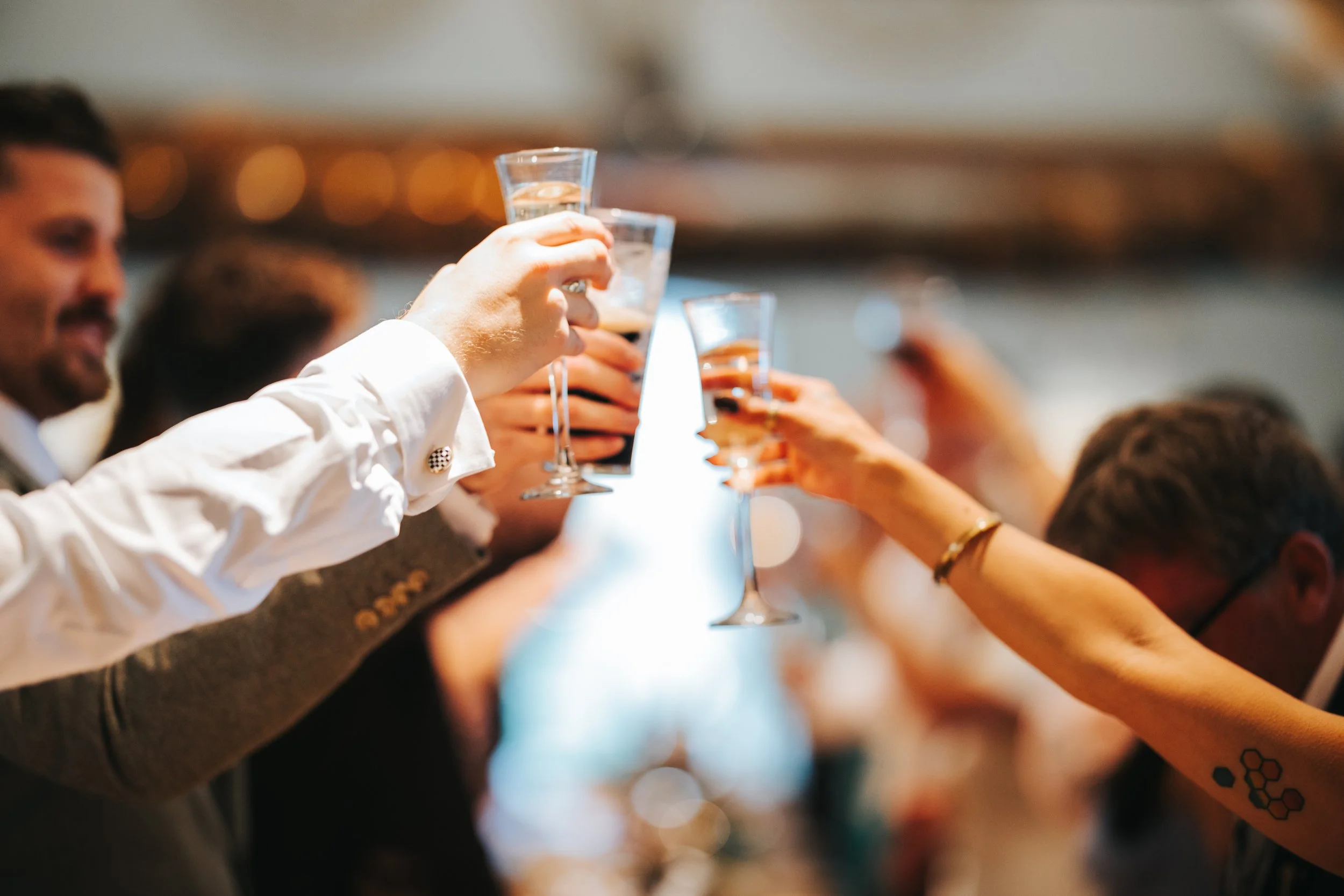 People raising glasses in a toast at a celebration or gathering.
