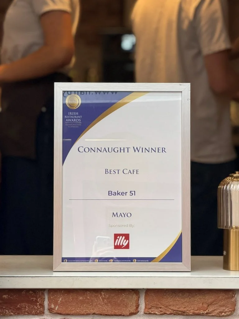 A framed award certificate on a counter recognizing Baker 51 as the best cafe, sponsored by Illy, at the Irish Restaurant Awards.