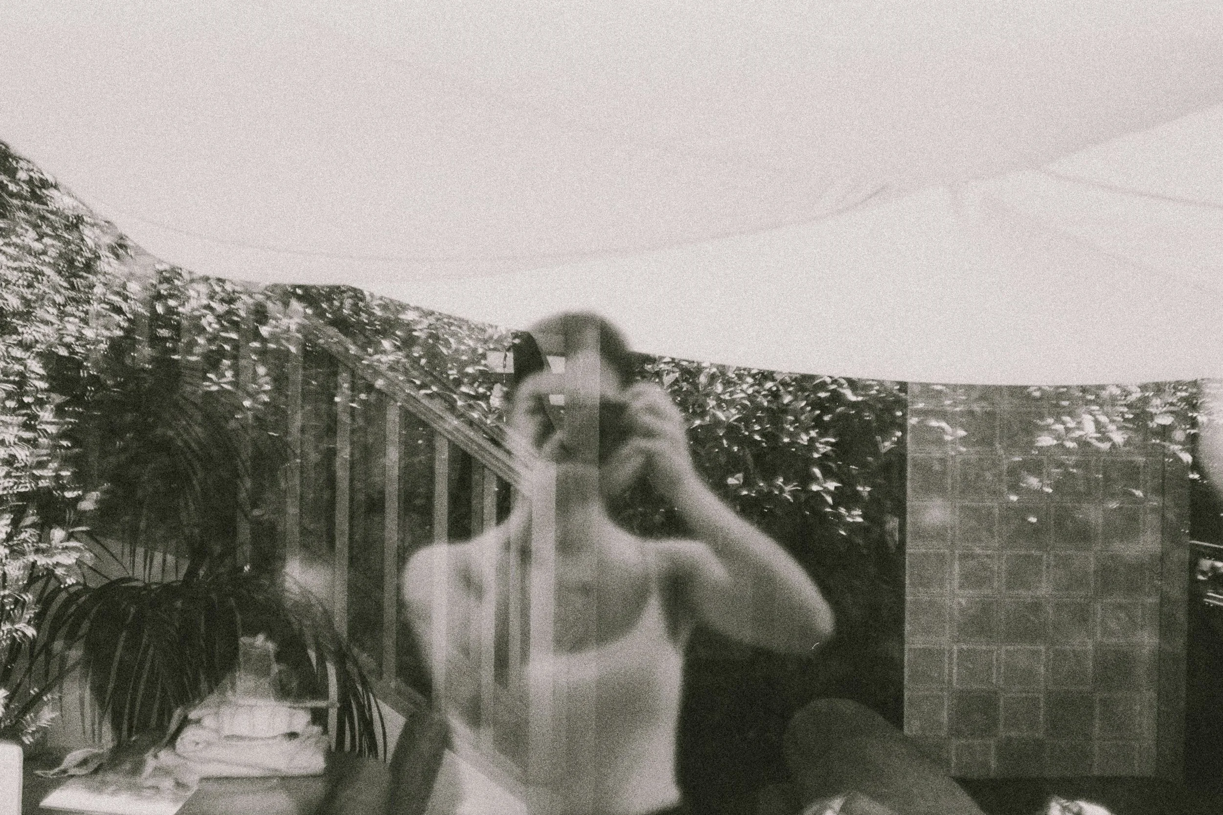 Black and white double exposure self-portrait through glass