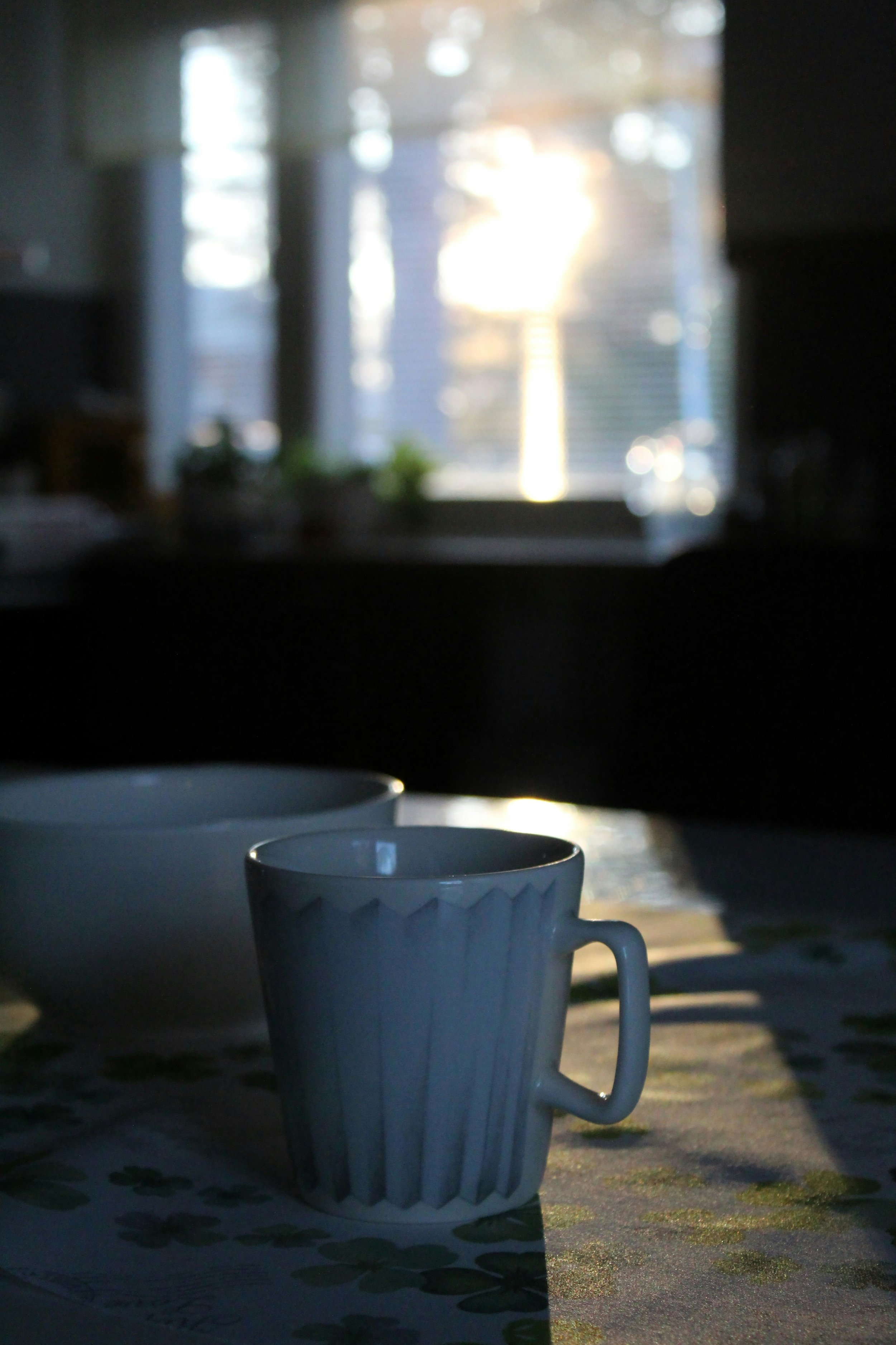 Coffee cup on kitchen table in morning light