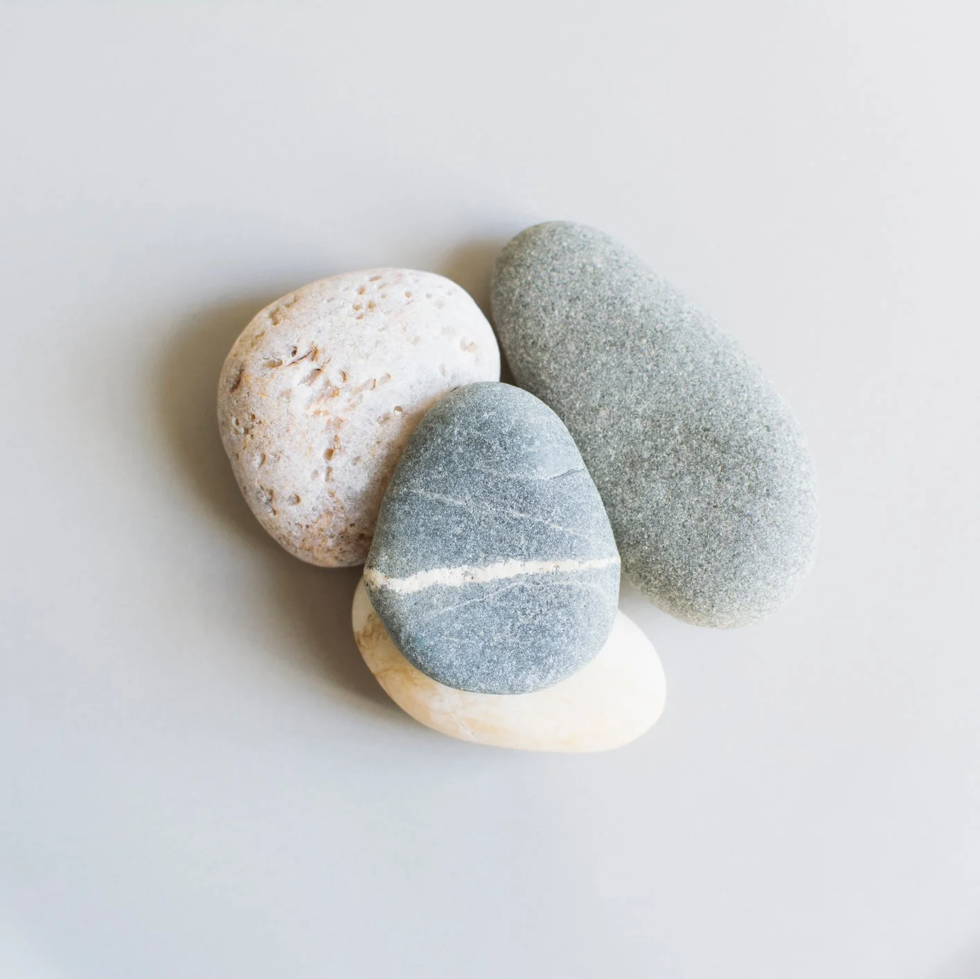 Smooth beach pebbles in cream and gray tones clustered together
