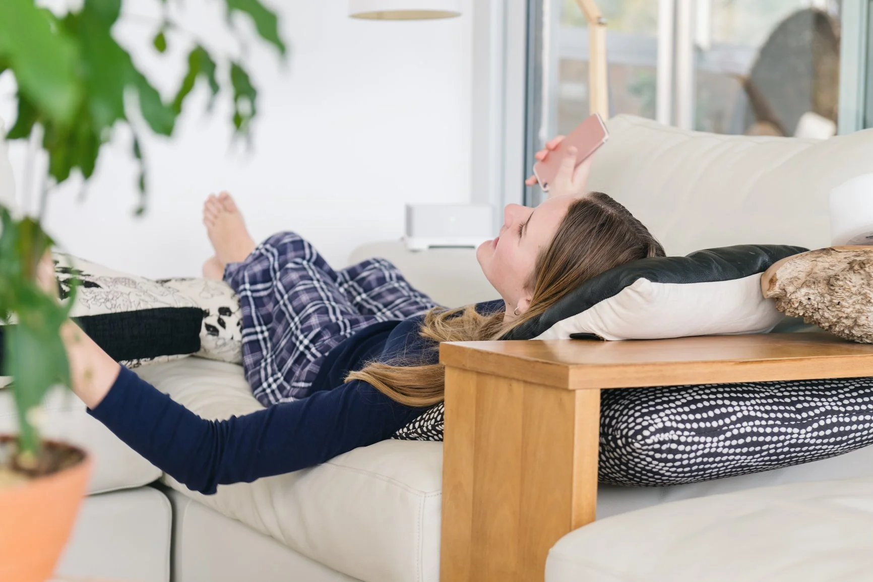 Teenager lying on couch talking on phone and laughing during college admission decisions season