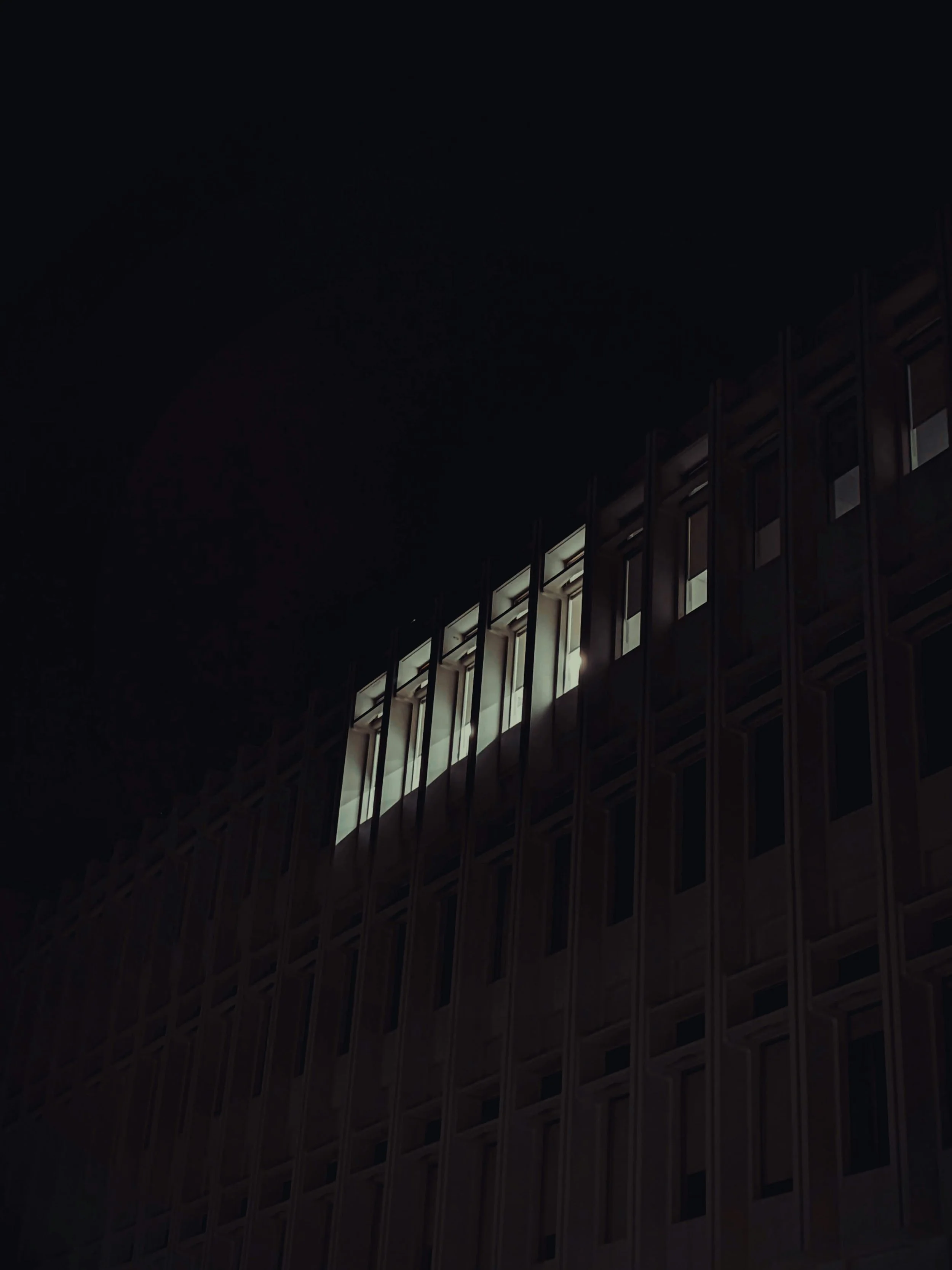 Office building at night with lit windows