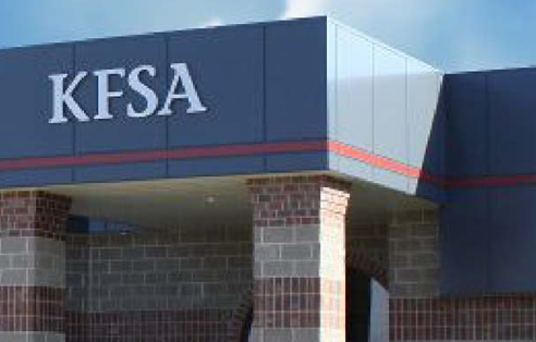 KESA sign on a building with brick and metal siding.