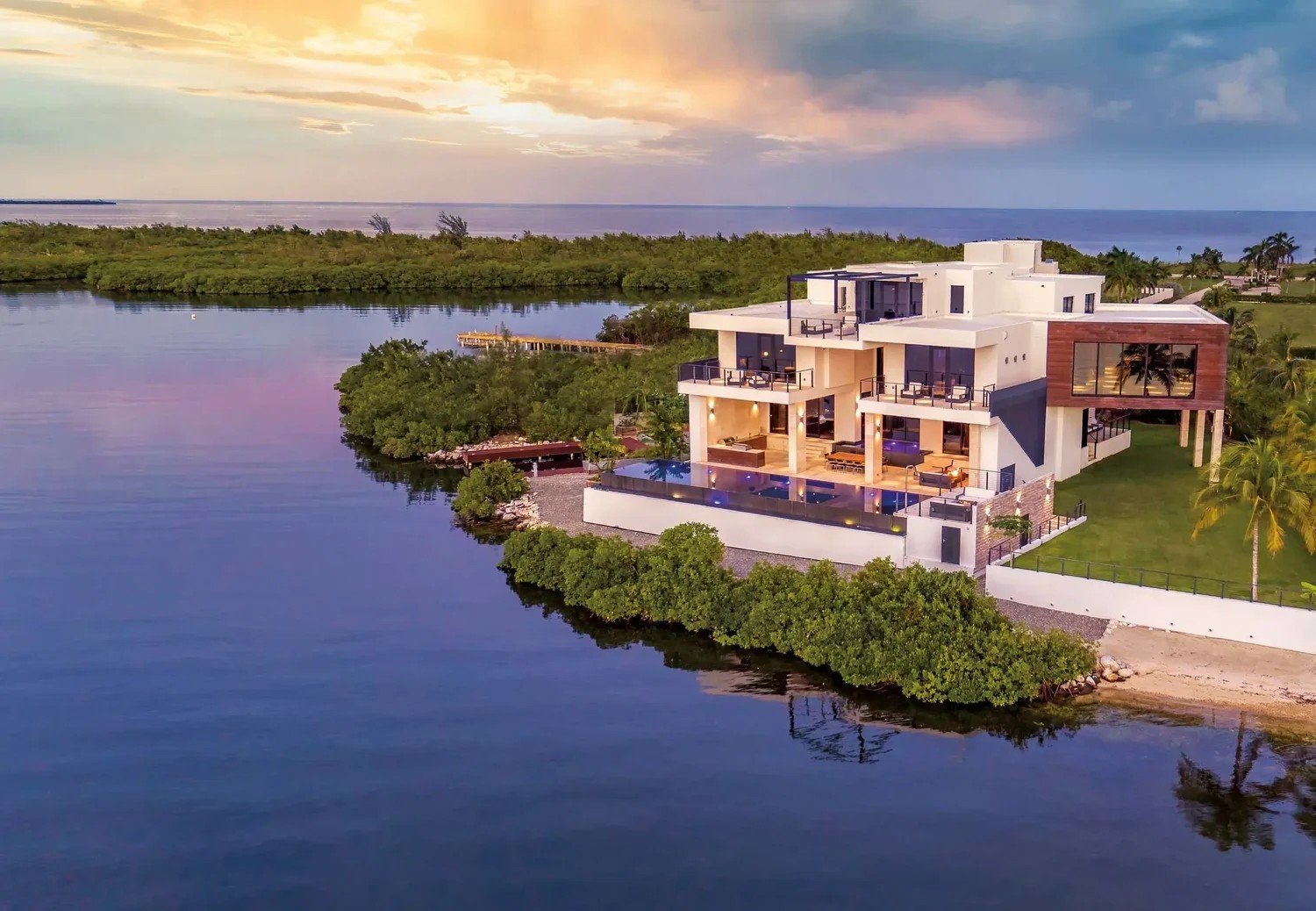 Aerial drone photo of a waterfront home in Grand Cayman at sunset