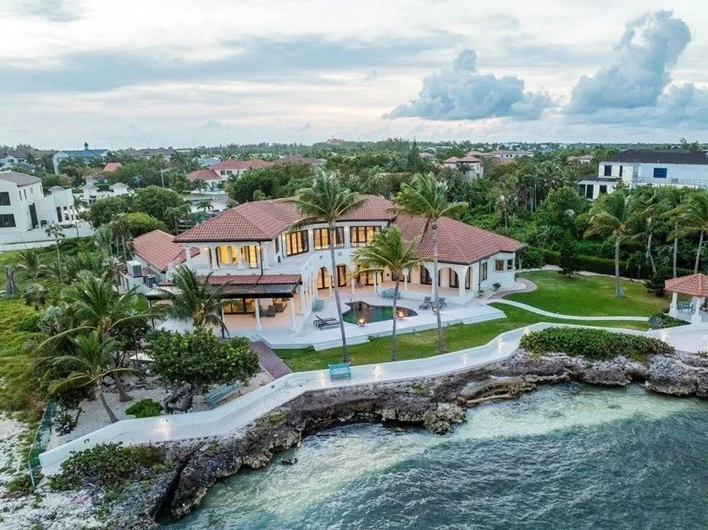Aerial drone view of an ironshore seawall and waterfront home in Grand Cayman