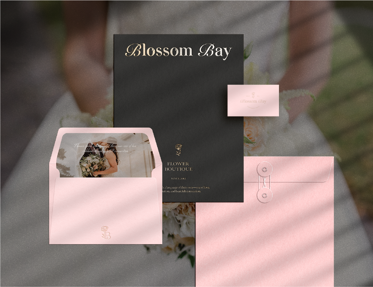 Pink and black floral boutique stationery set including envelopes, cards, and a flyer with a flower logo and Elegant lettering for Blossom Bay.