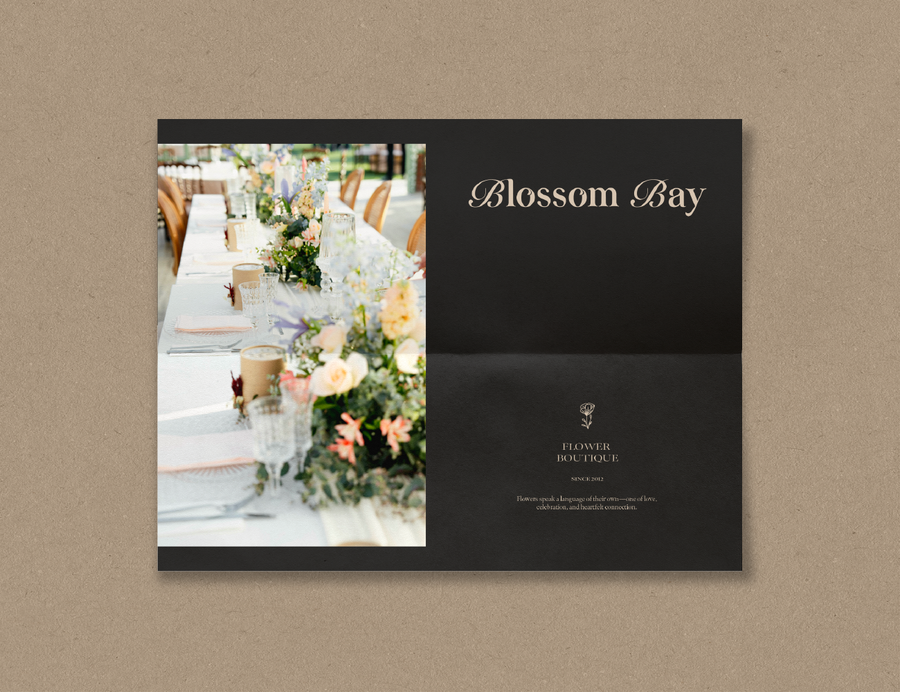 Wedding or event invitation showing a decorated table with floral arrangements, glasses, and table settings, with text reading 'Blossom Bay' and 'Flower Boutique'.