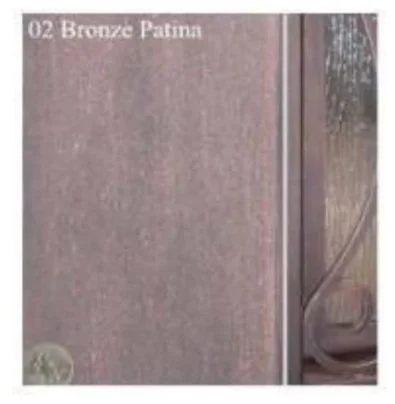 Sample of bronze patina on a surface with a portion of a mirror or reflective surface on the right.