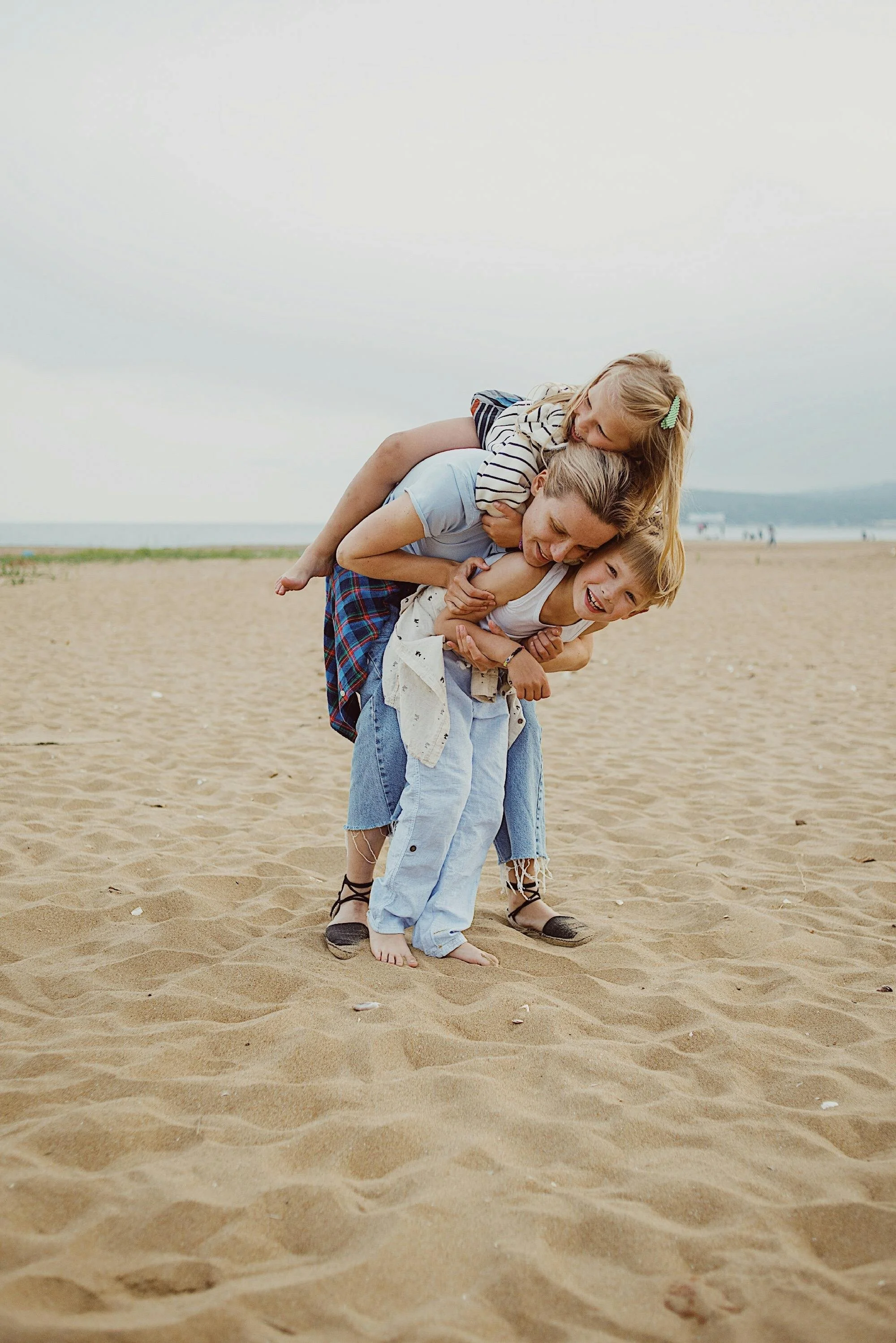 Mom holding her son with her daughter on her back