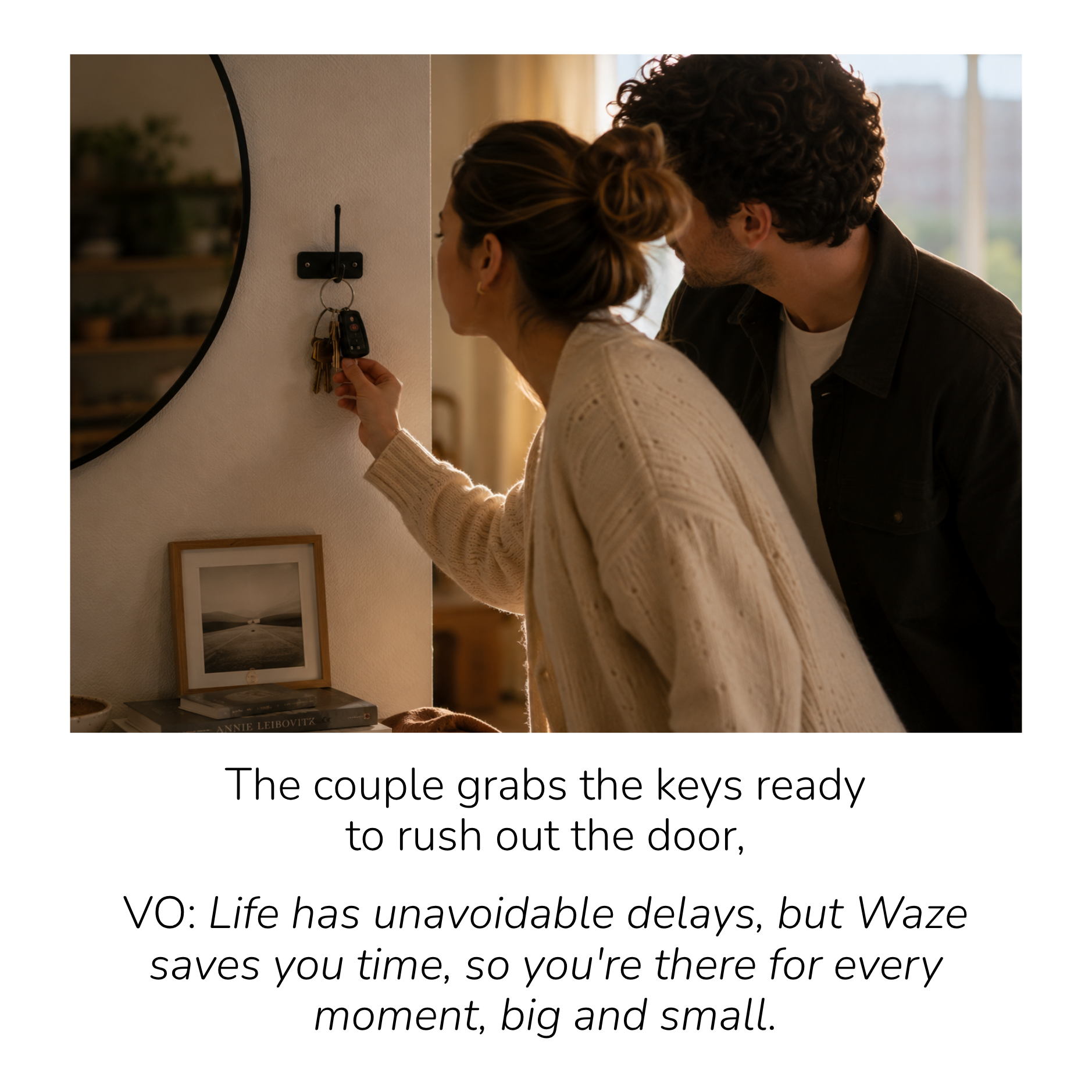 A young couple is near a wall with a small round mirror and a photograph. The woman is holding a set of keys that she is about to place on a key hook. The man is leaning in, and they are both focused on the keys. The caption indicates they are grabbi