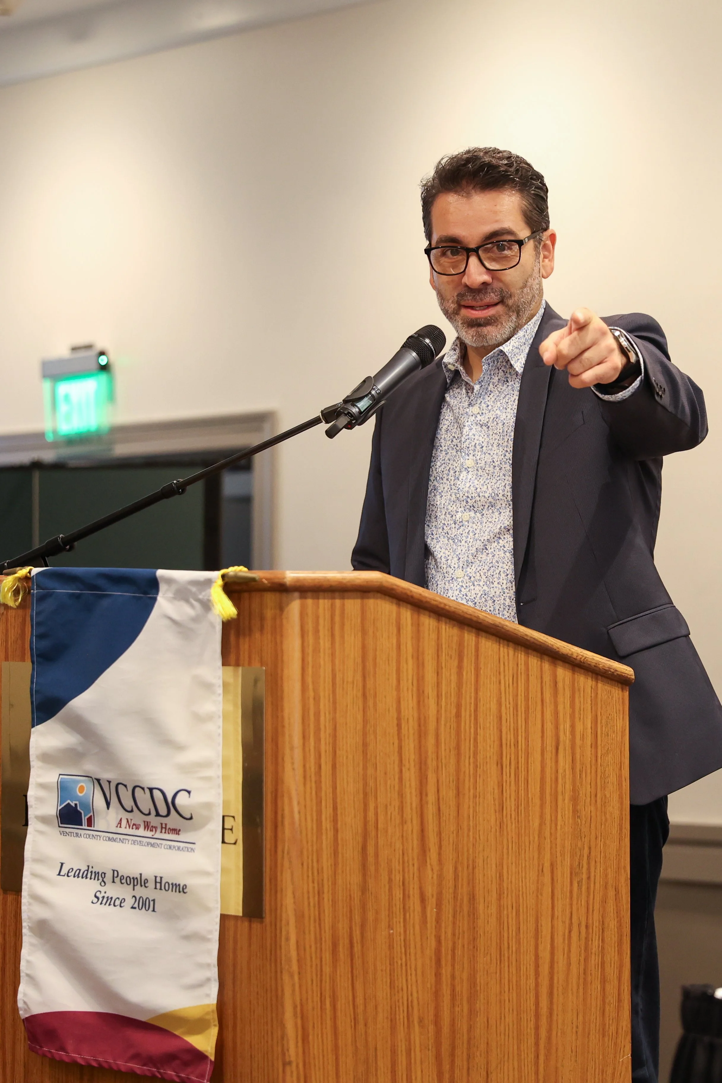 Man speaking at podium at indoor community event