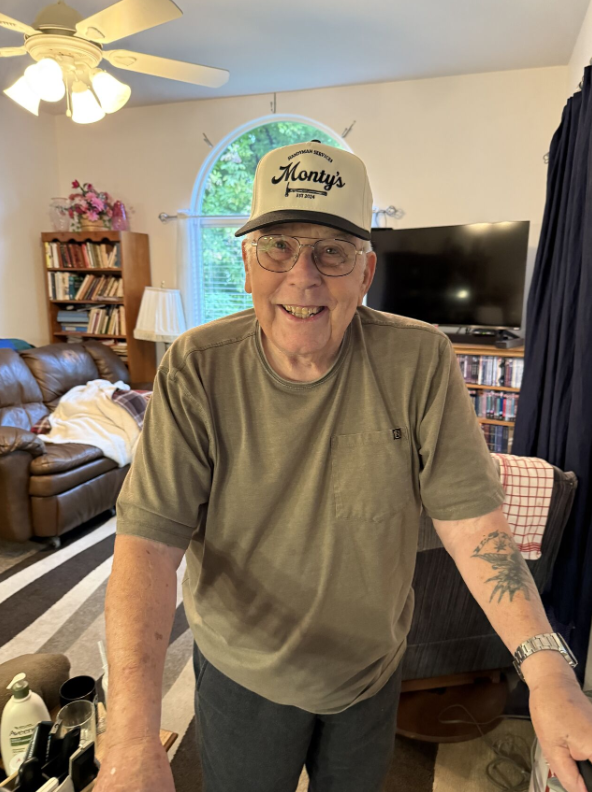 An image of Larry Montgomery, smiling with his Monty's Handyman services hat on in his living room.