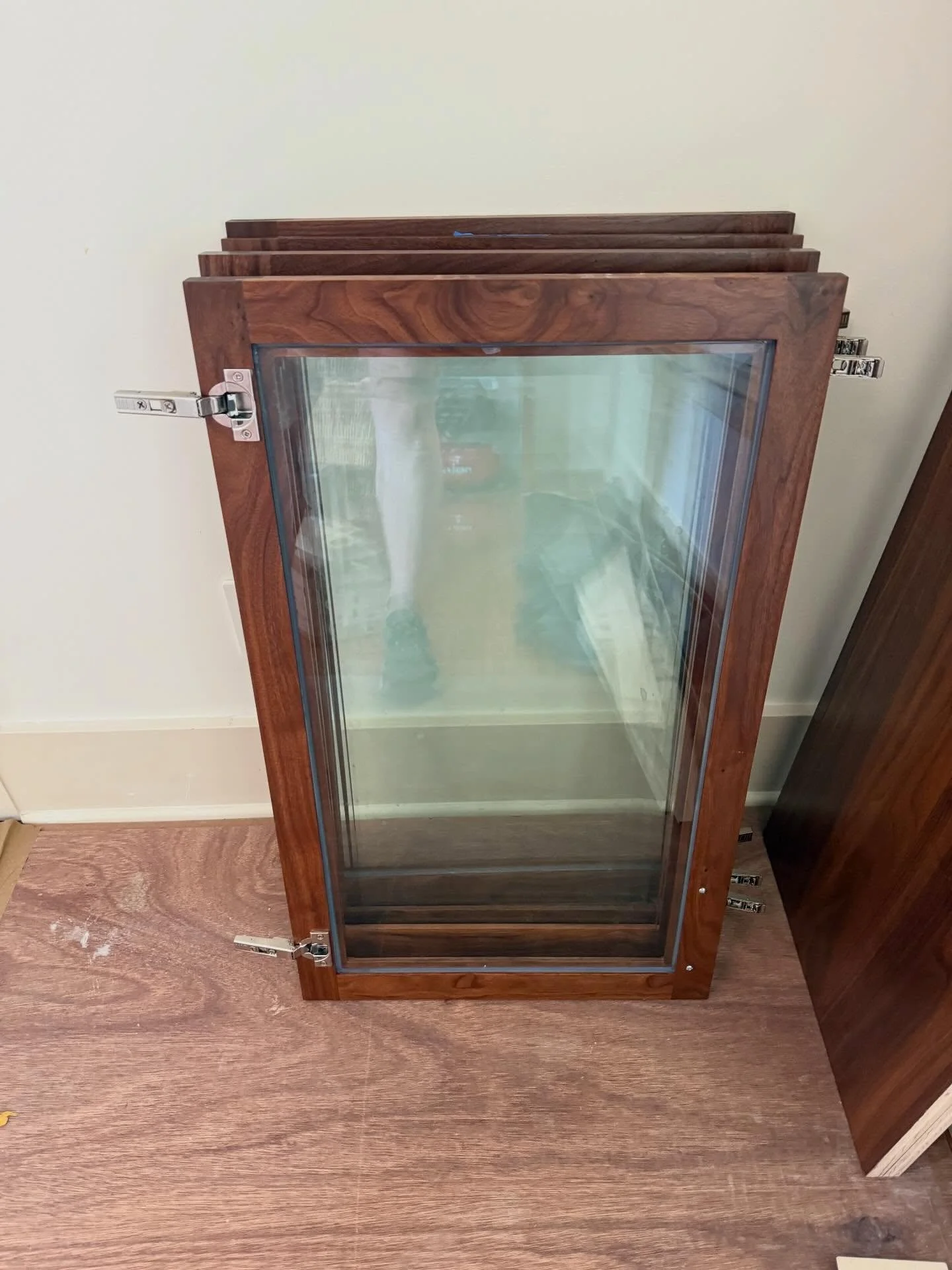 Beveled glass inlays with tempered glass shelves in a illuminated bar cabinet.